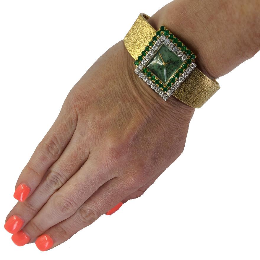 Pre-Owned 18 Karat Yellow Gold Bueche-Girod Manual Wind Wristwatch With Jade Stone Dial. Bezel Features 27 Emeralds & 27 Diamonds Totaling Approximately 5.50 Carats. Adjustable Length 6.5 to 7 Inches. Finished Weight Is 77.4 Grams.