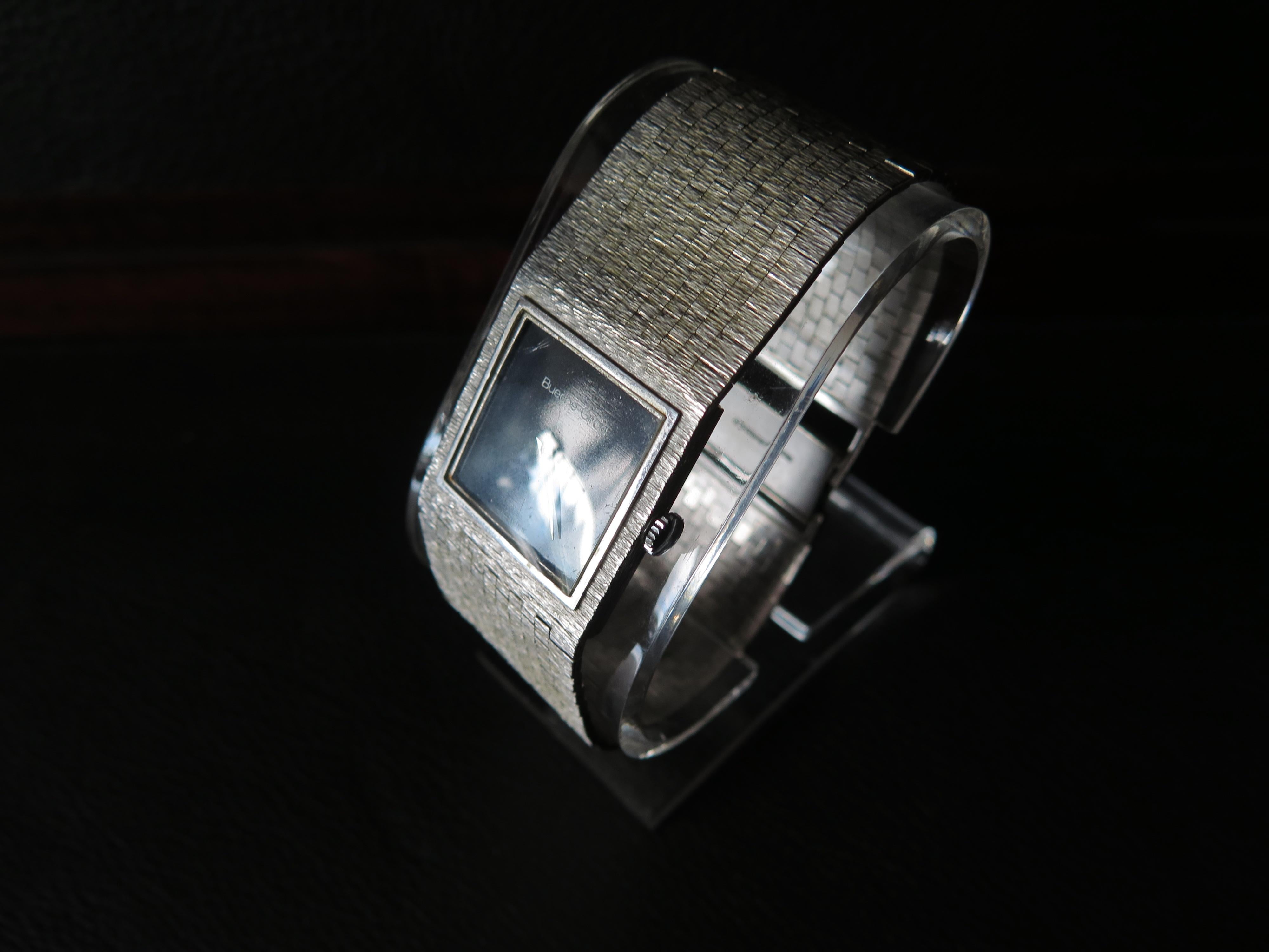 Un raro reloj de Bueche Girod, vendido en 1973. Fabricada en oro blanco de 9 quilates. Movimiento de cuerda manual, esfera negra original. La pulsera integrada mide aprox. 26 mm de ancho.