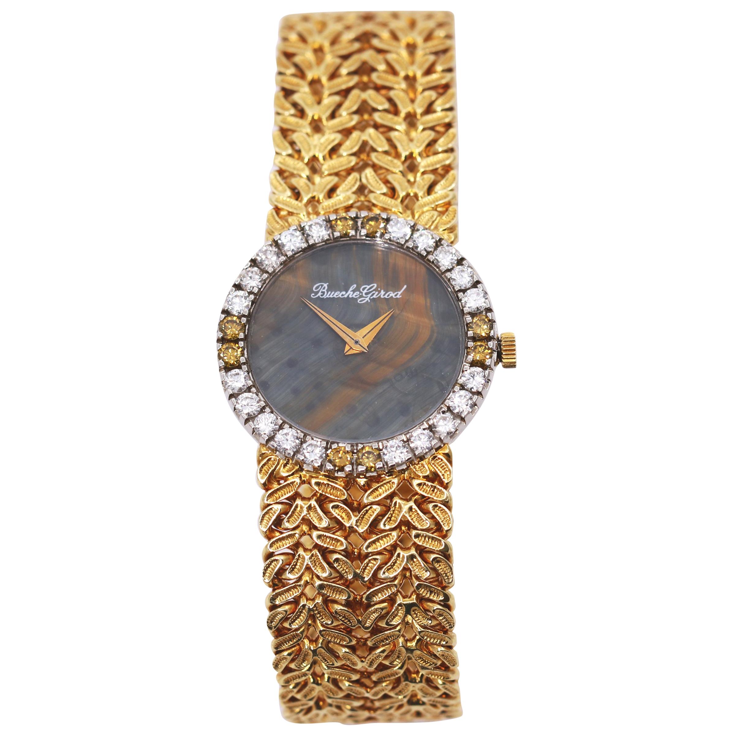 A ladies 18K yellow gold Bueche Girod watch centered around an 18mm translucent stone dial with gold veining. The bezel of the wristwatch is set with 20 white round brilliant cut diamonds, and 8 fancy champagne colored diamonds. The fancy colored