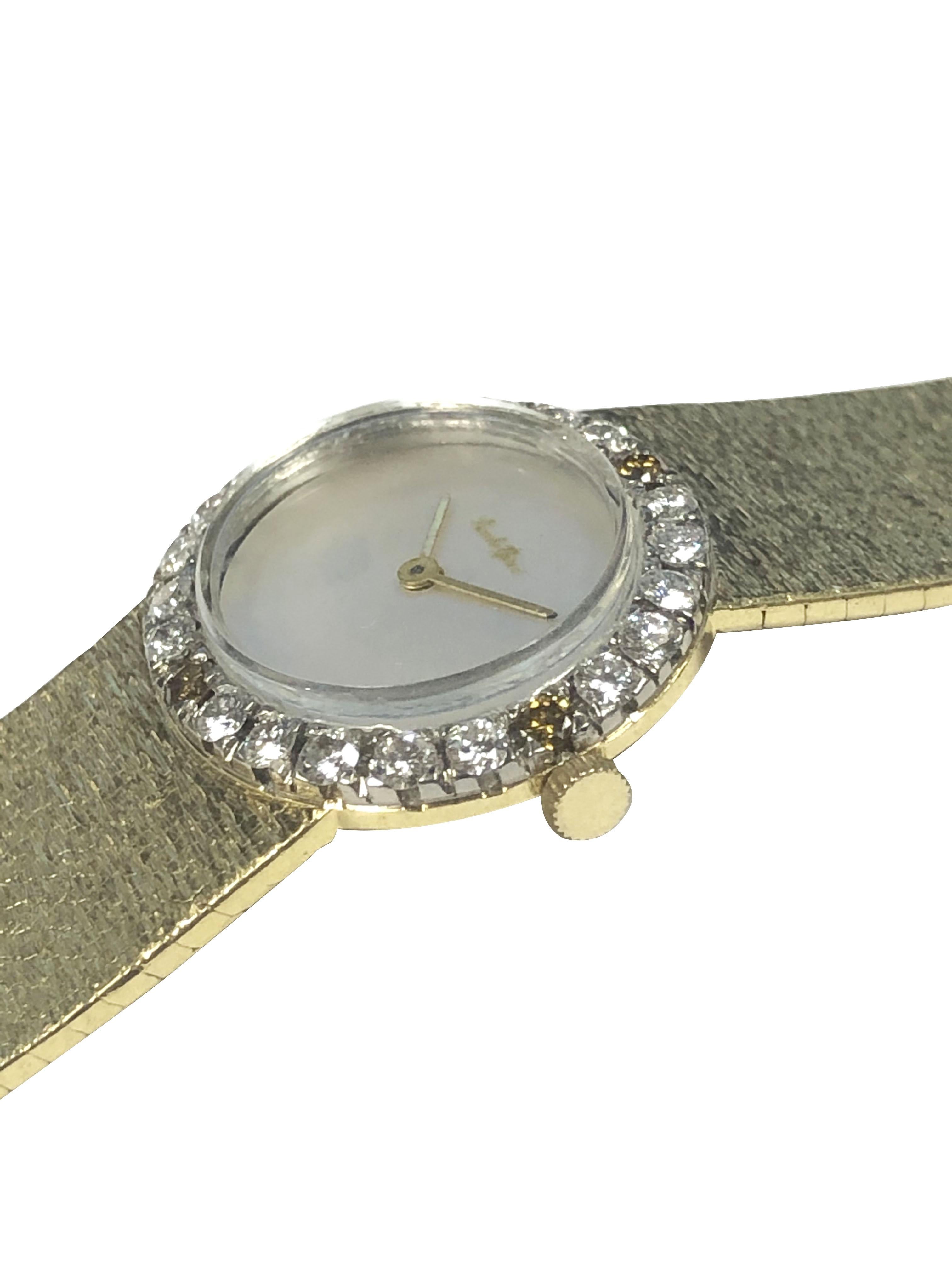 Circa 1980 Bueche Girod Ladies Wrist Watch, 26 X 22 M.M. 18K Yellow Gold 2 Piece case with a White Gold bezel of White and Cognac Round Brilliant cut Diamonds totaling 1 Carat, 17 Jewel mechanical, manual wind movement, Mother of Pearl Dial. 5/8