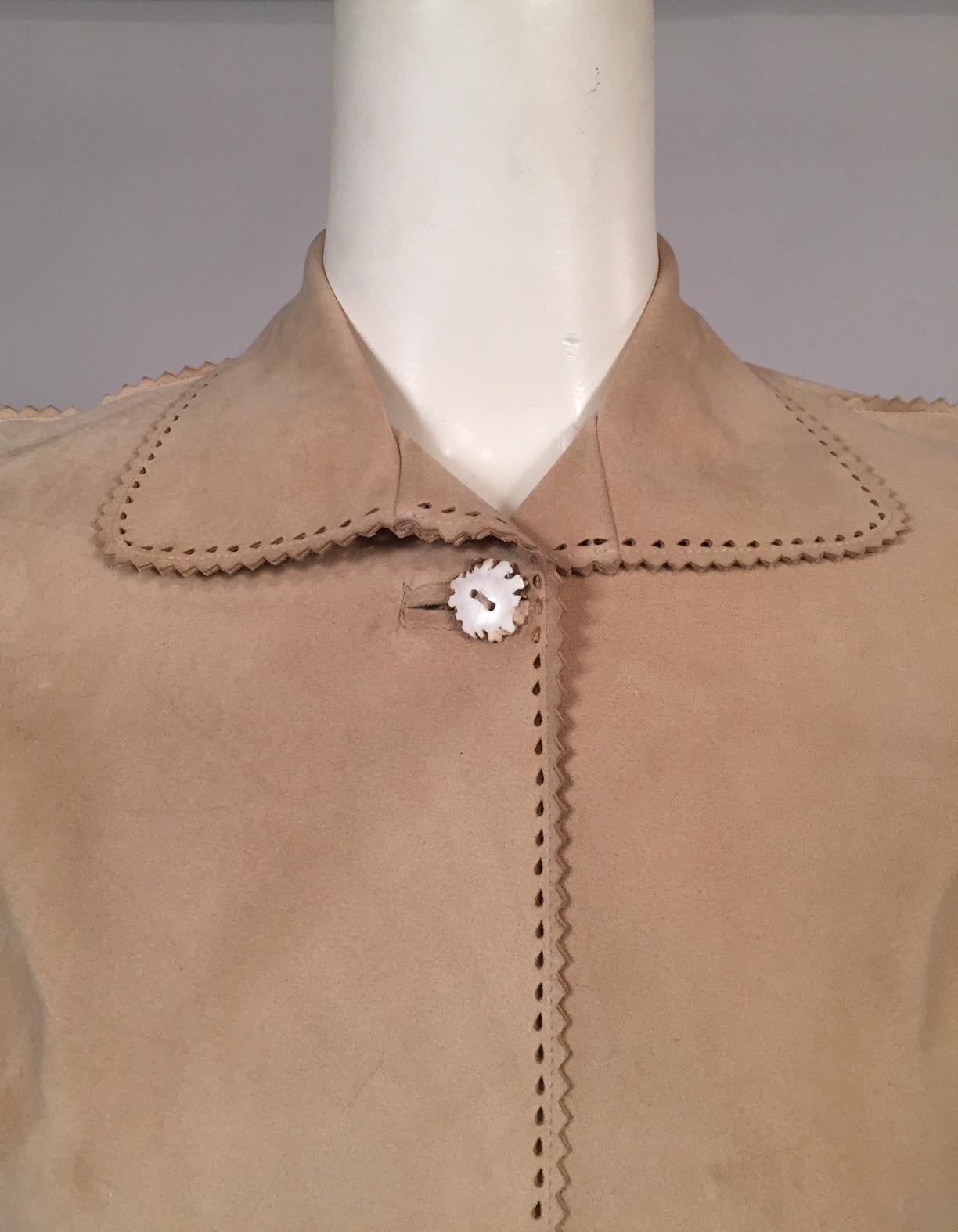 Cette veste en daim doux comme du beurre a été conçue pour en faire moins. Il n'est pas doublé, avec un seul bouton en corne au col. Le col, le centre du devant et l'ourlet sont décorés de petites perforations en forme de larme. Toutes les coutures