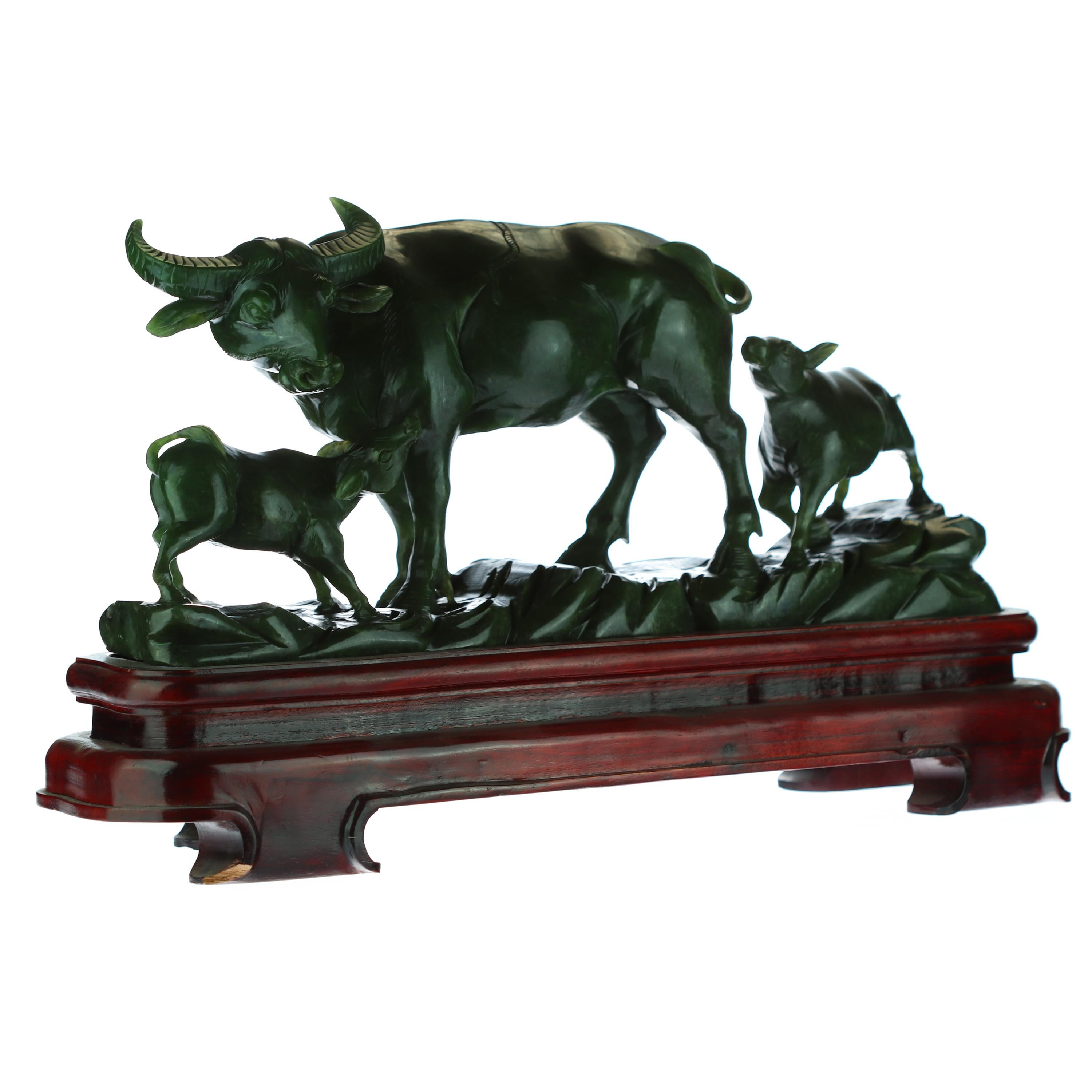 Stunning antique Chinese sculpture. Hand carved Canadian Jade that creates a unique buffalo family figurine. Full of detail and magic where the animal family enjoys nature in a pacific way. Natural colors with a vivid feeling of joy and animal