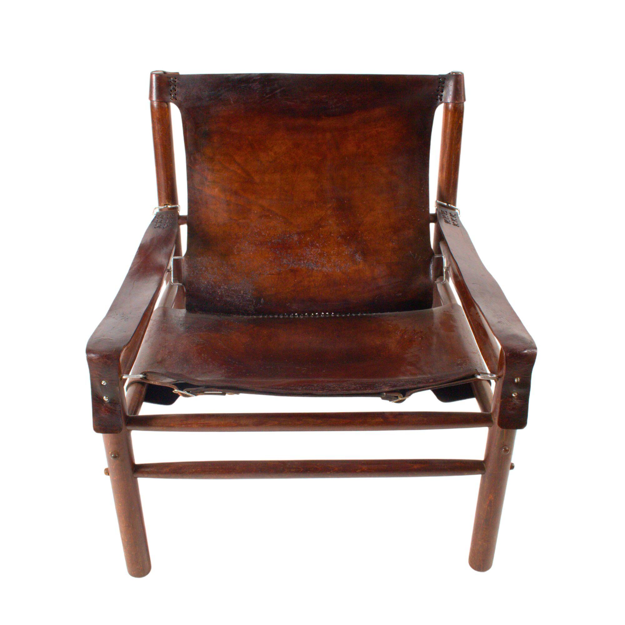 Cette élégante paire de fauteuils Safari des années 1970 dégage un charme intemporel avec sa combinaison de cuir de buffle et de bois de hêtre robuste. Le cuir a été récemment nettoyé, mais conserve sa riche patine ; le bois de hêtre est en