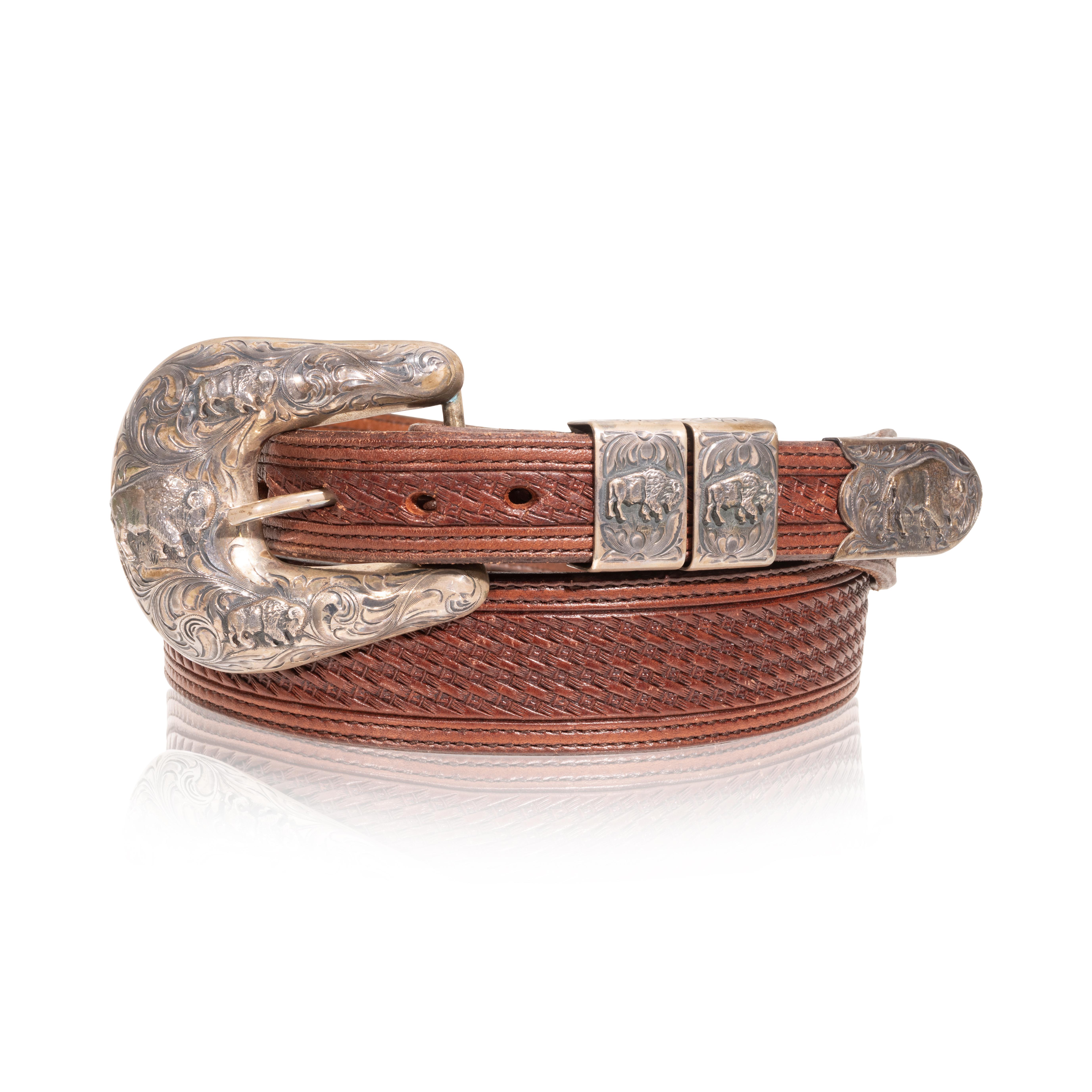 Vogt sterling buckle set on chocolate basket weave leather belt. Buckle features one large bison and two smaller bison with scrolled leaf desig aurrounding. Mirrored design on loops and end piece. Stamped 
