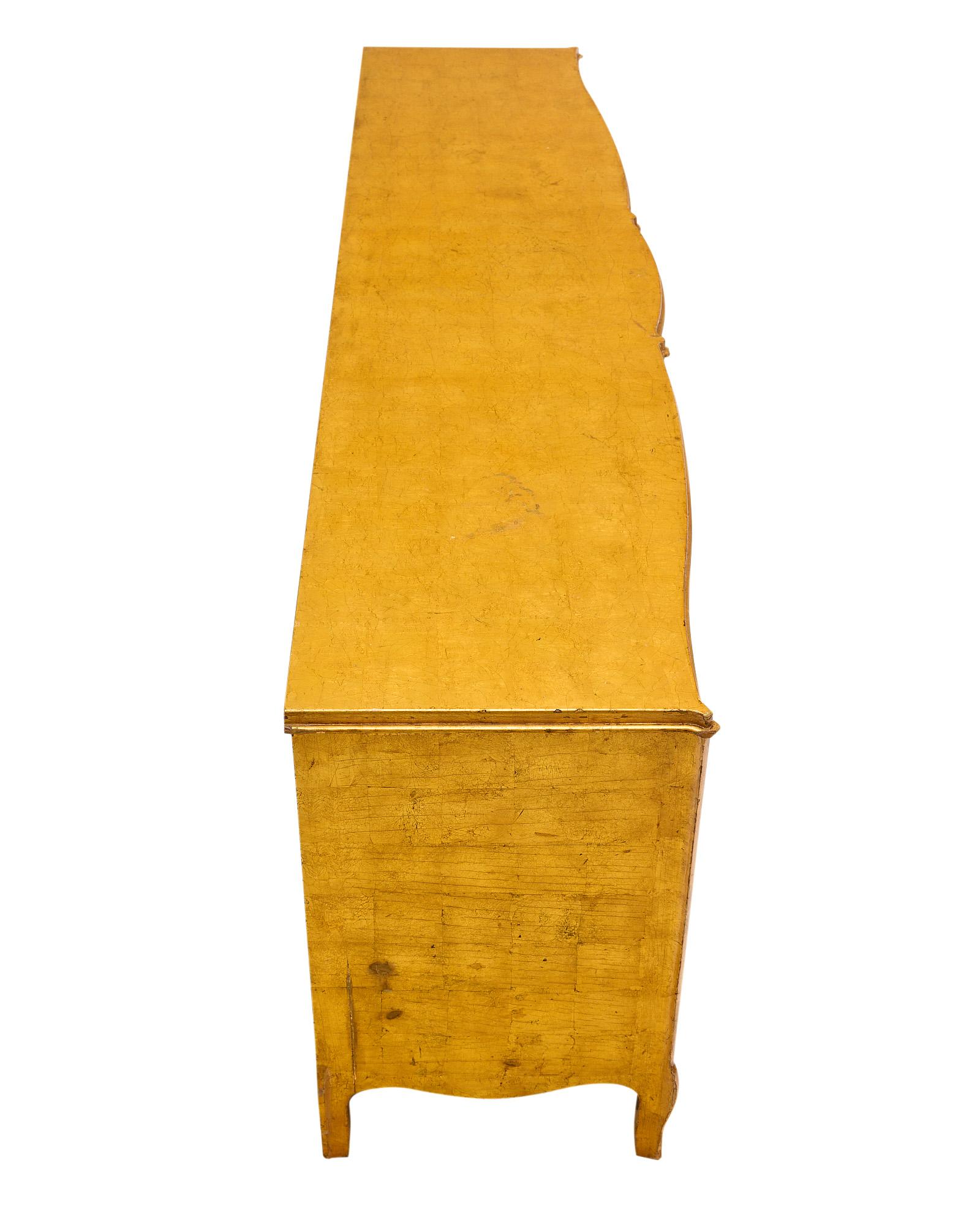Buffet / enfilade designed by Jean Royere, the leading designer of Maison Gouffé in Paris, from the Art Deco period in France made of beech wood that has been finished with a gold leaf lacquer. There are two doors that open to interior shelving and