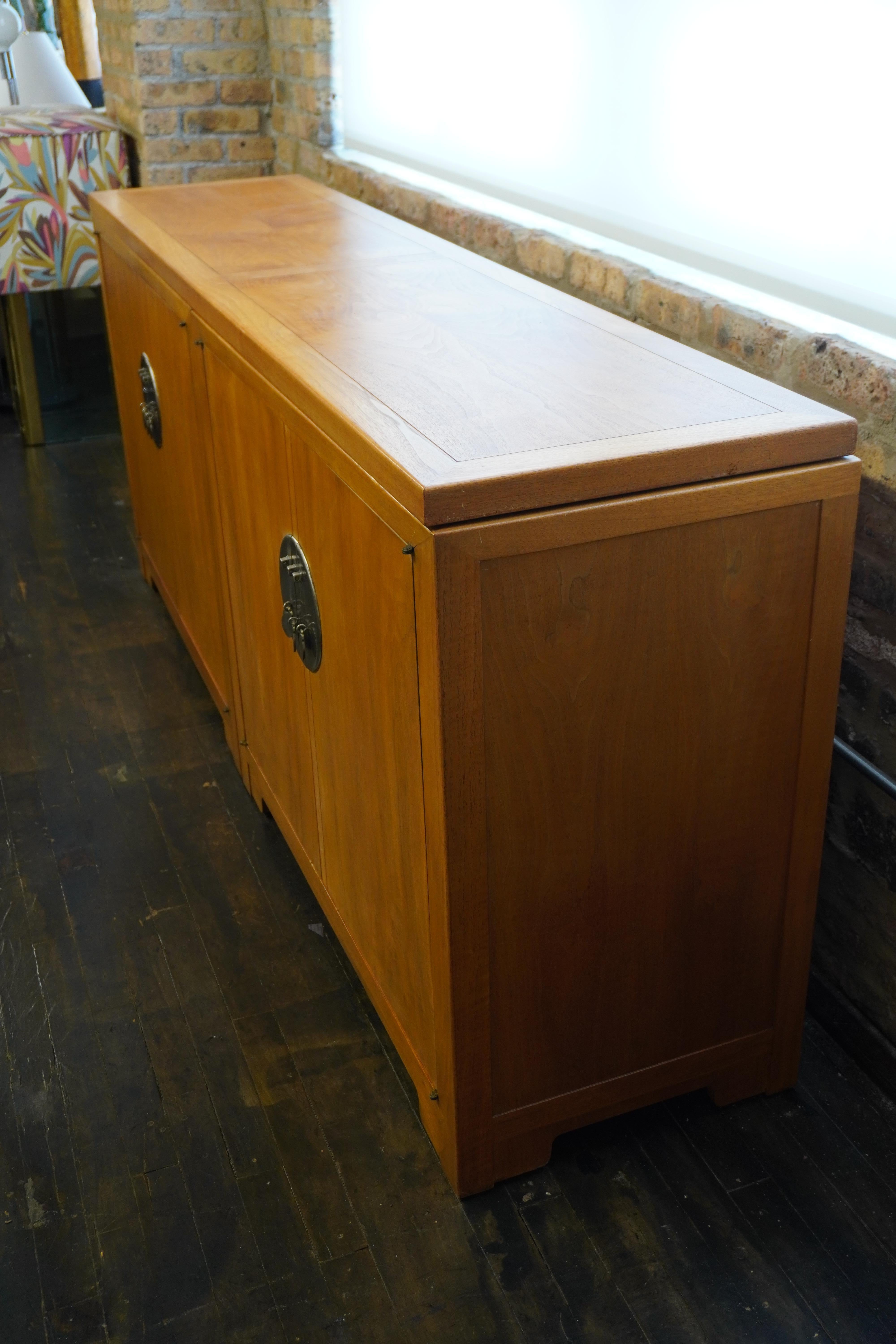 Uno splendido buffet (credenza) in tre parti disegnato da Michael Taylor per Baker Furniture.  Questo pezzo fa parte della collezione Far East. 

Presenta 2 armadietti inferiori e un piano lungo che si blocca per collegare i due armadietti (buffet a