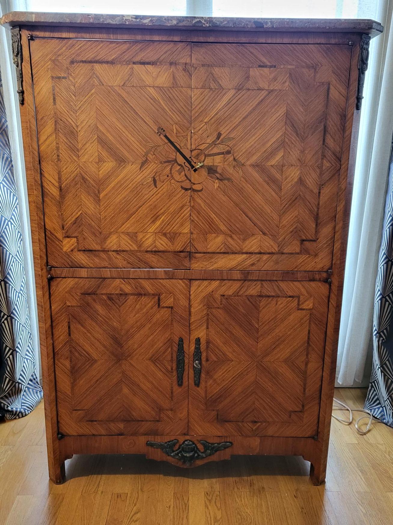 Meuble en bois de rose  style Louis XVI  recouvert d'une plaque de marbre et des finitions en bronze sculptées.
Adapté en meuble pour recevoir une  télévision ainsi que pour la hi-fi, il se compose de 4 portes et se divise en 2 compartiments ,don un