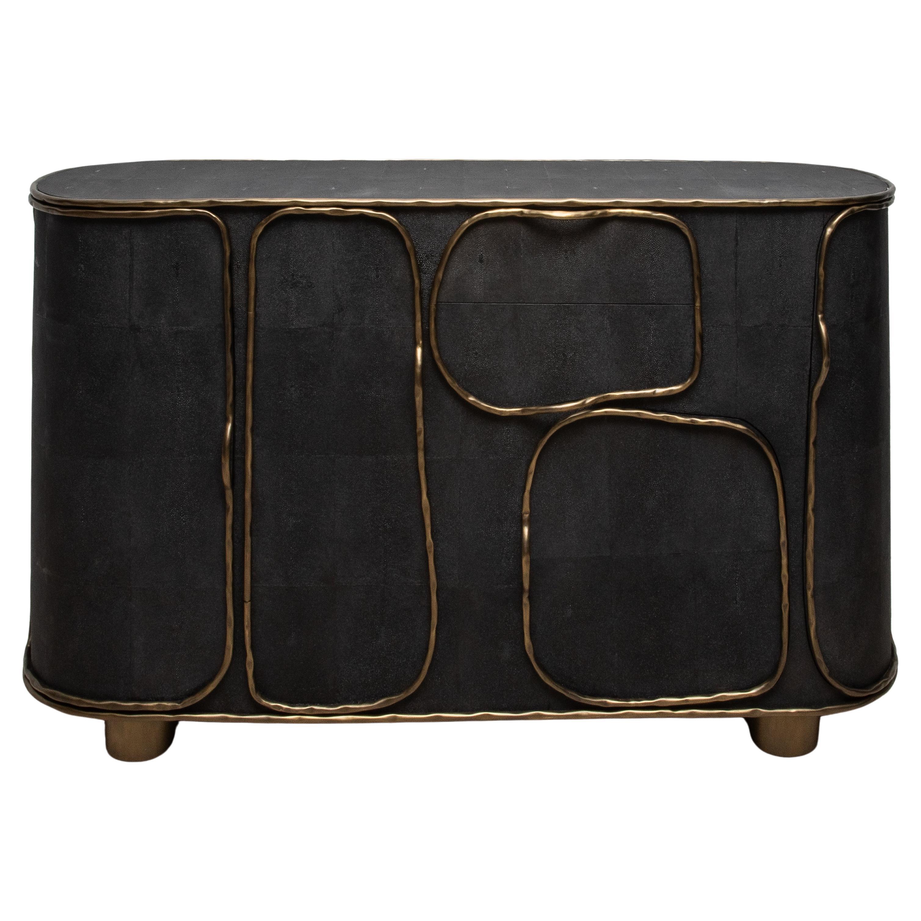 The Arianne Buffet by R&Y Augousti is a masterpiece of modern luxury, blending exquisite craftsmanship with an avant-garde design. Handcrafted from luxurious black shagreen, this buffet showcases a unique textured surface, beautifully contrasted by