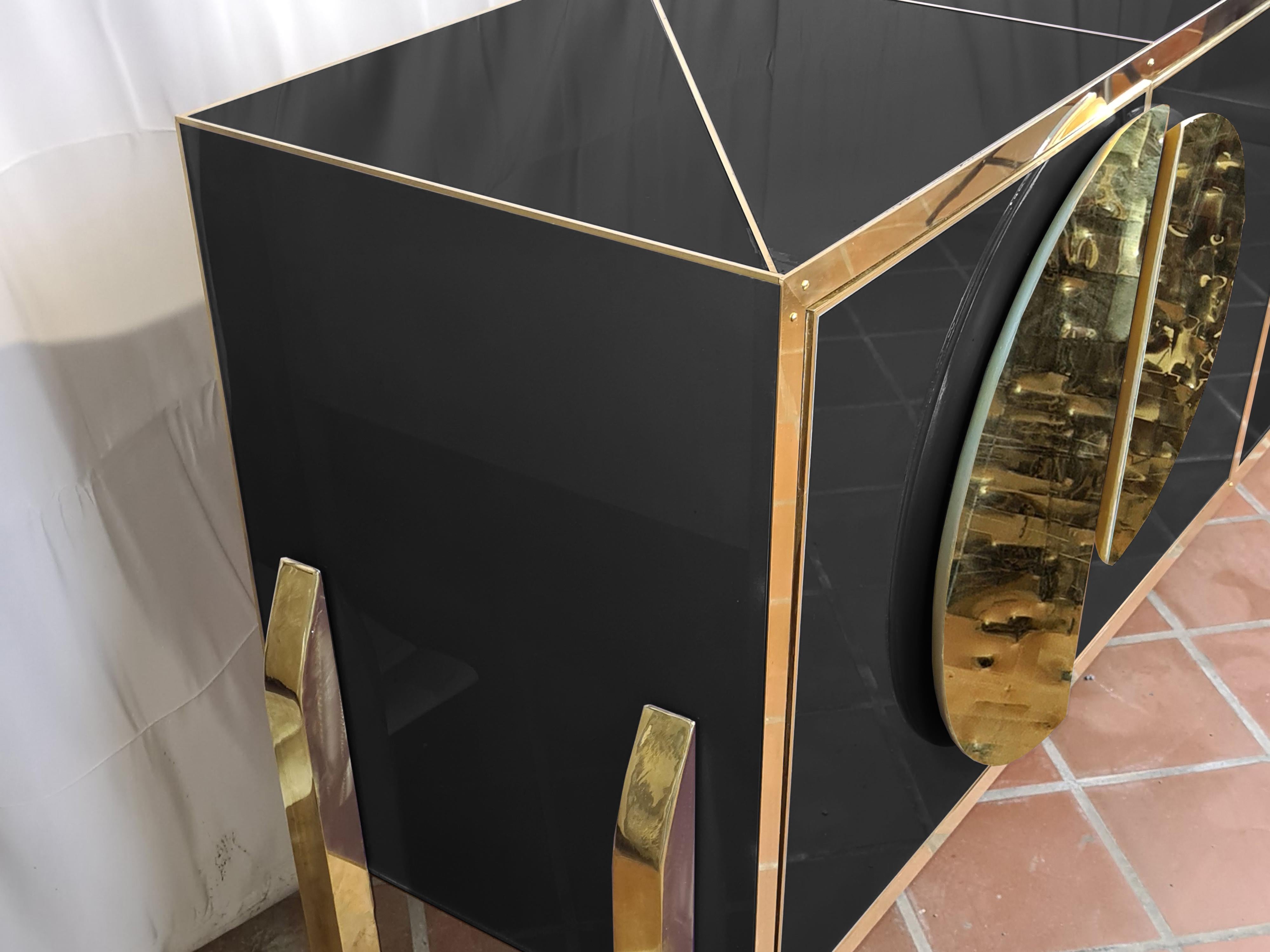 This exquisite Italian-made buffet sideboard perfectly blends modern elegance with traditional craftsmanship. 

The elegant birch wood structure is beautifully complemented by black Murano glass, creating a striking visual contrast. 

Brass handles