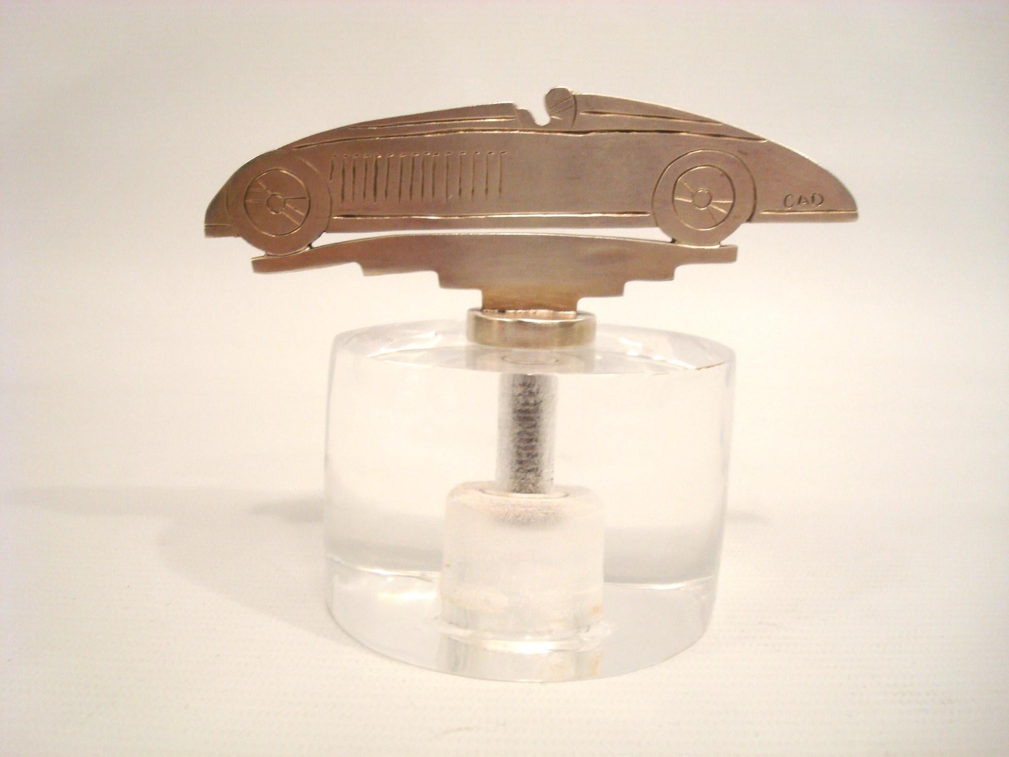 Bugatti Tank Car Mascotte / Ornement de capot / Presse-papiers. France 1930.
Sculpture en bronze argenté représentant une Bugatti Type 32 ¨Tank¨ Car.
Monté sur une base acylique. Signé CAD.
Joli presse-papier de bureau.

Littérature : Mascottes