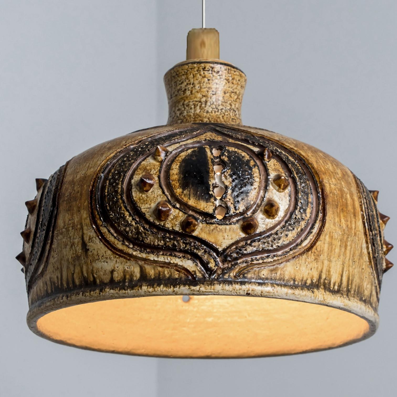 Stunning round hanging lamp with an unusual shape, made with rich brown and yellow colored ceramics, manufactured in the 1970s in Denmark. We also have a multitude of unique colored ceramic light sets and arrangements, all available on the