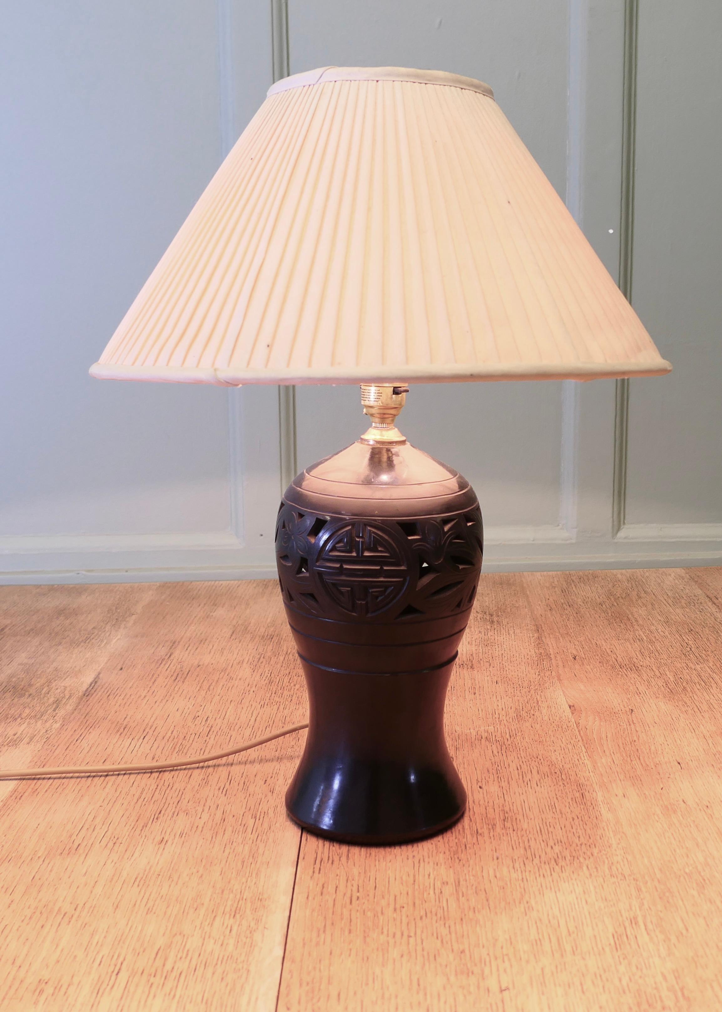 Lampe à poser Bulbous en céramique noire
La lampe est une pièce en céramique de belle forme, décorée de motifs de style oriental et couronnée d'un abat-jour plissé en forme de coolie. 
La lampe et l'abat-jour sont en bon état d'usage, le câblage est