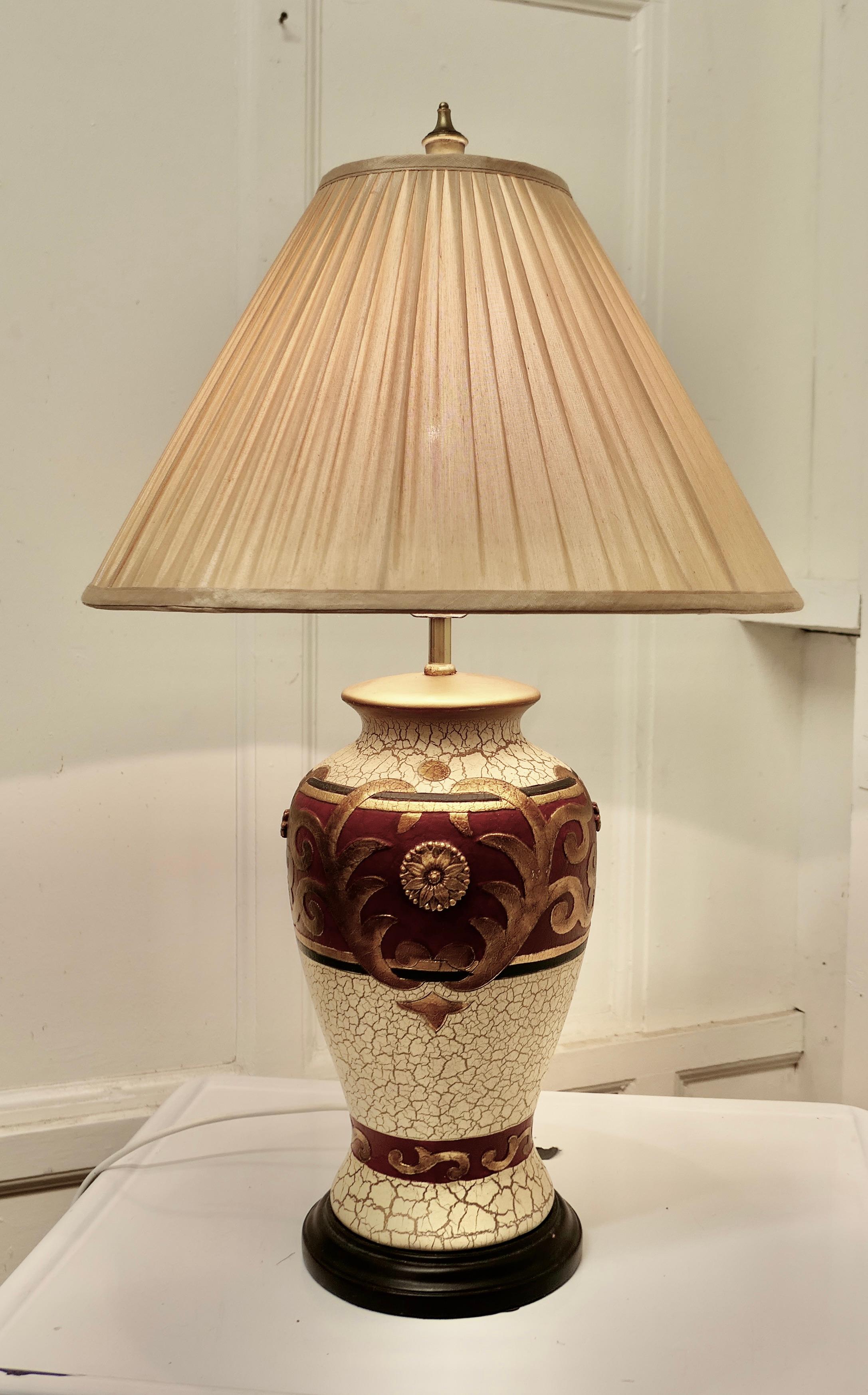Bulbous folk art painted table lamp. 

This an attractive pottery lamp painted in a folk art style, in crackle finish Gold, Cream and Red, the paint has now aged in colour and developed a charming finish, the lamp has its own pleated silk lamp