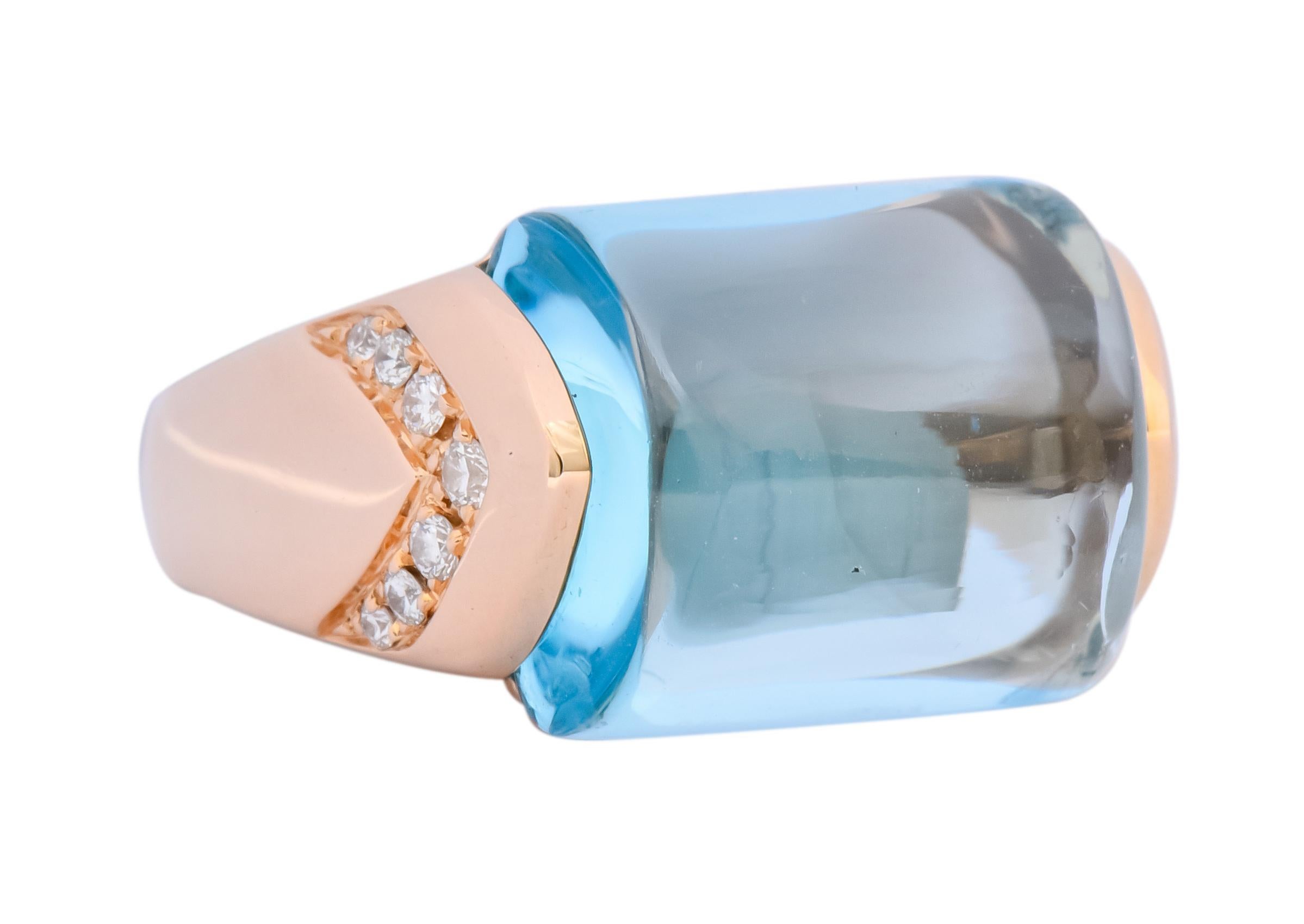 Centering a rectangular cabochon blue topaz weighing approximately 14.00 carats, transparent and very light blue in color

Flanked by high shoulders with bead set round brilliant cut diamonds, in a chevron motif, weighing approximately 0.24 carat