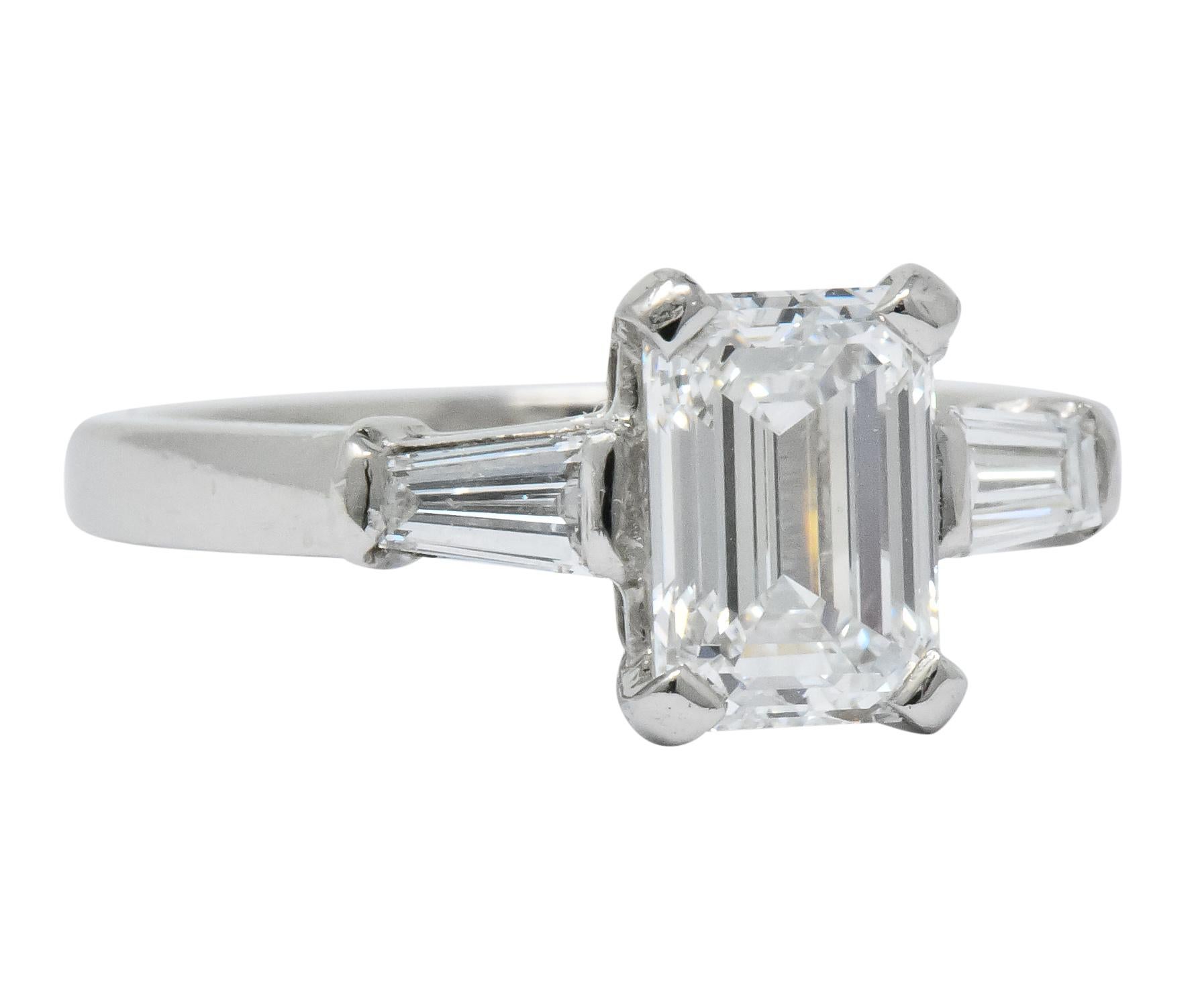 Centering a basket-set emerald cut diamond weighing 1.20 carats, E color and VVS2

Flanked by channel set, tapered baguette cut diamonds weighing approximately 0.28 carat total, E/F color and VVS clarity

1.48 CTW

Fully signed Bulgari with Italian