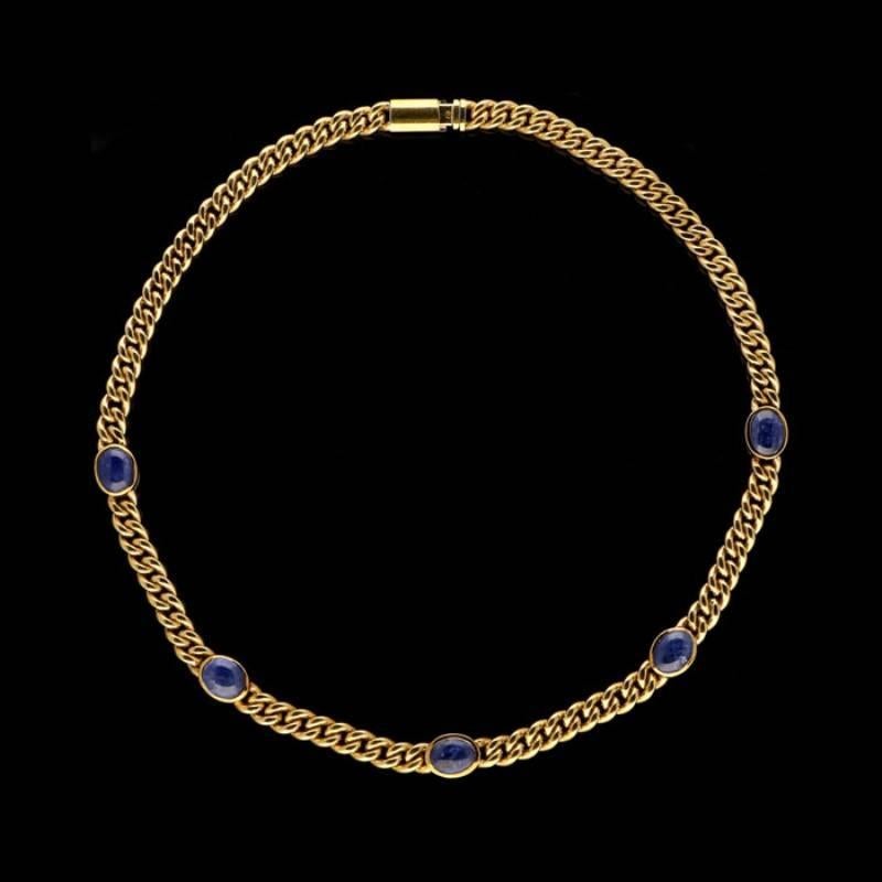 An 18 carat yellow gold chain by Bulgari c.1970s composed of uniform flattened curb links set to the front half with five oval sapphire cabochons in rub over settings, all to a tongue and box clasp.

5 sapphire cabochons estimate to weigh a combined