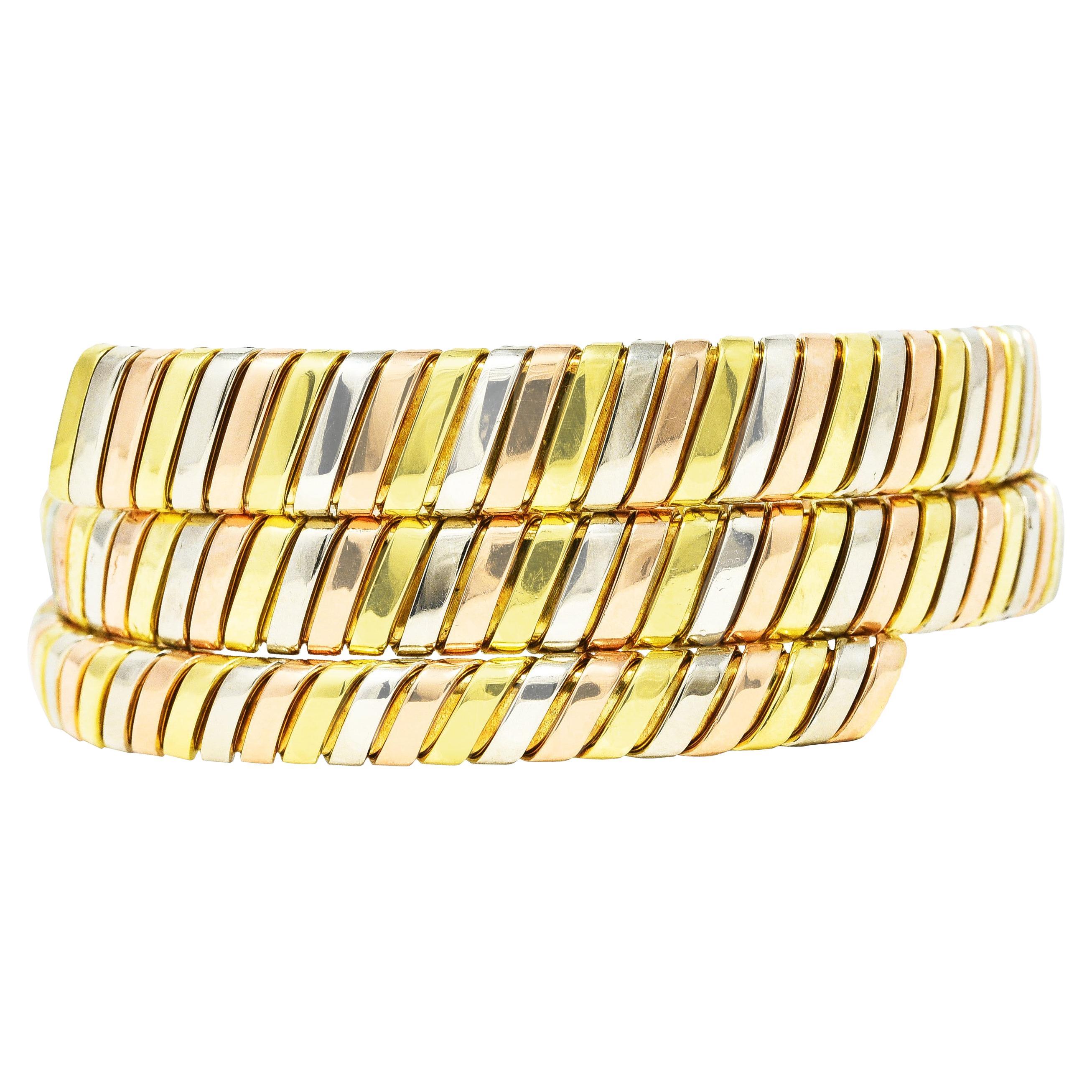 Bracelet is designed a flexible tubogas wrap graduating in size. With alternating segments of yellow, white, and rose gold. Completed by high polish finish. Stamped 750 with Italian assay marks for 18 karat gold. Fully signed Bulgari, Made in Italy.