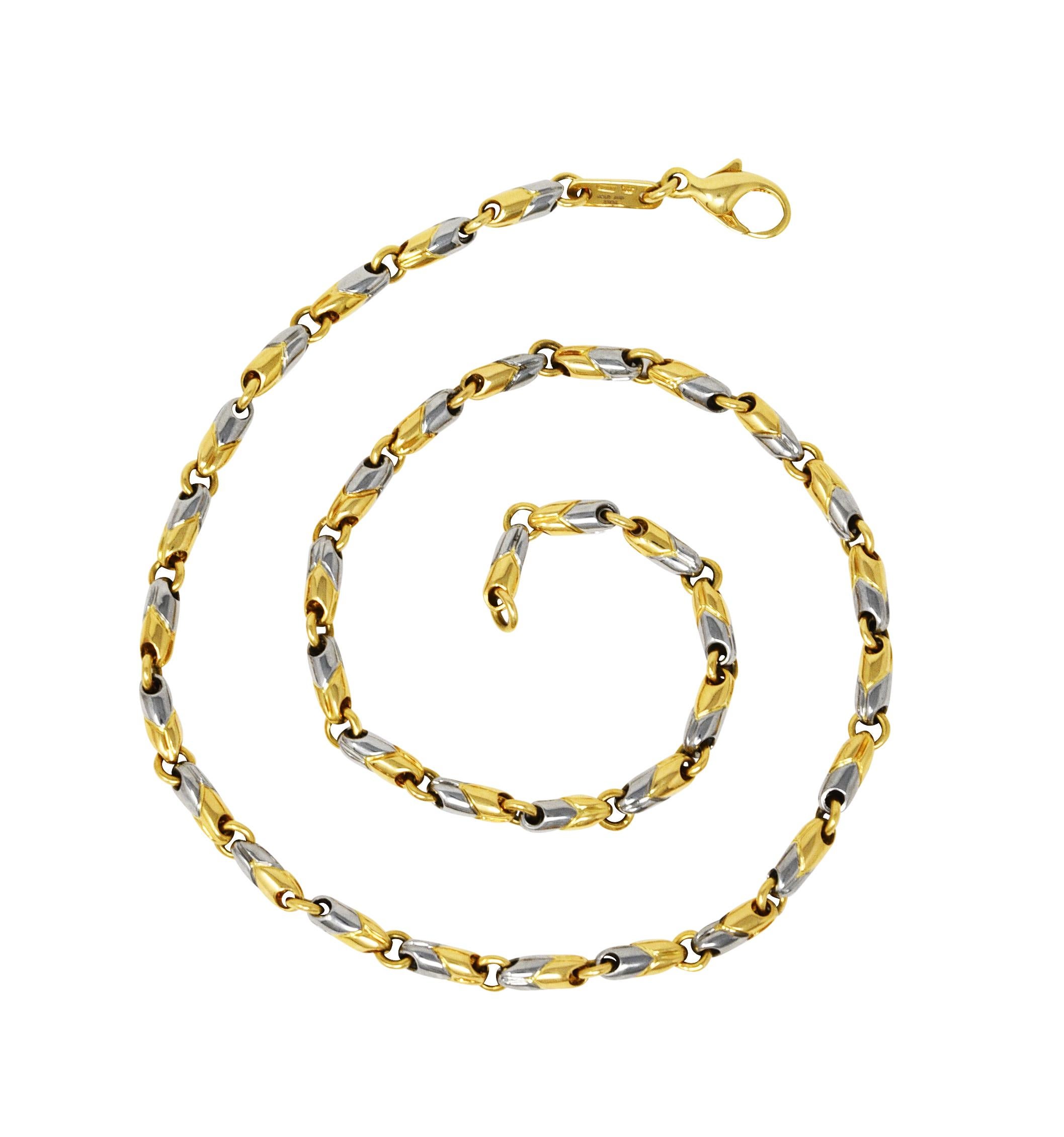 Le collier est composé de maillons striés en forme de tonneau avec le motif chevron signé Passo Doppio. Les liens sont composés pour moitié d'or blanc et pour moitié d'or jaune. Avec des liens d'écartement à anneau de saut. Complété par un fermoir à