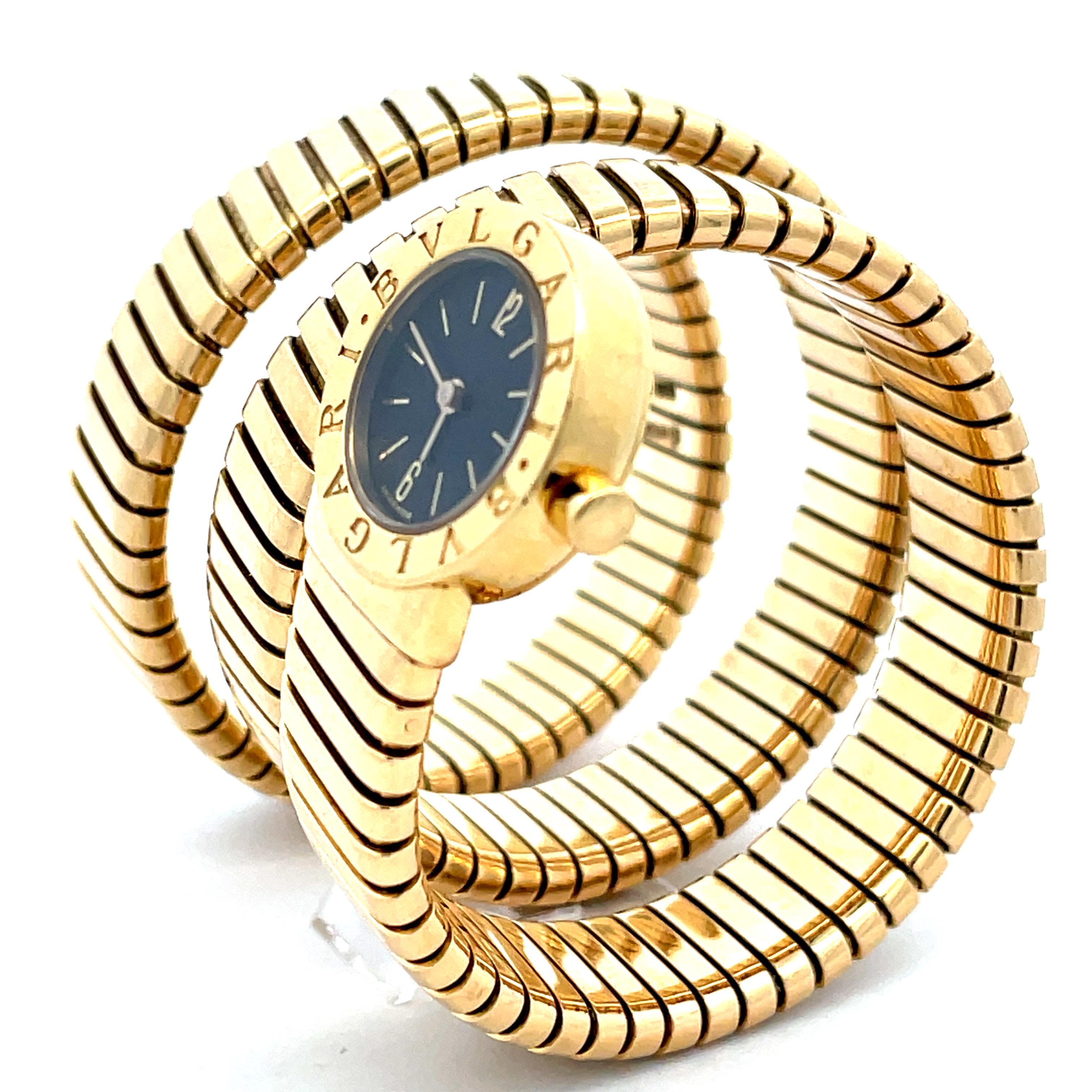 Il n'y a pas mieux que cette montre bracelet serpent Bulgari Tubogas pour femme en or jaune 18 carats. Cette montre à quartz a une petite tête ronde et un cadran noir. Une montre emblématique que vous porterez pour toujours. 
1978 circa.
Une