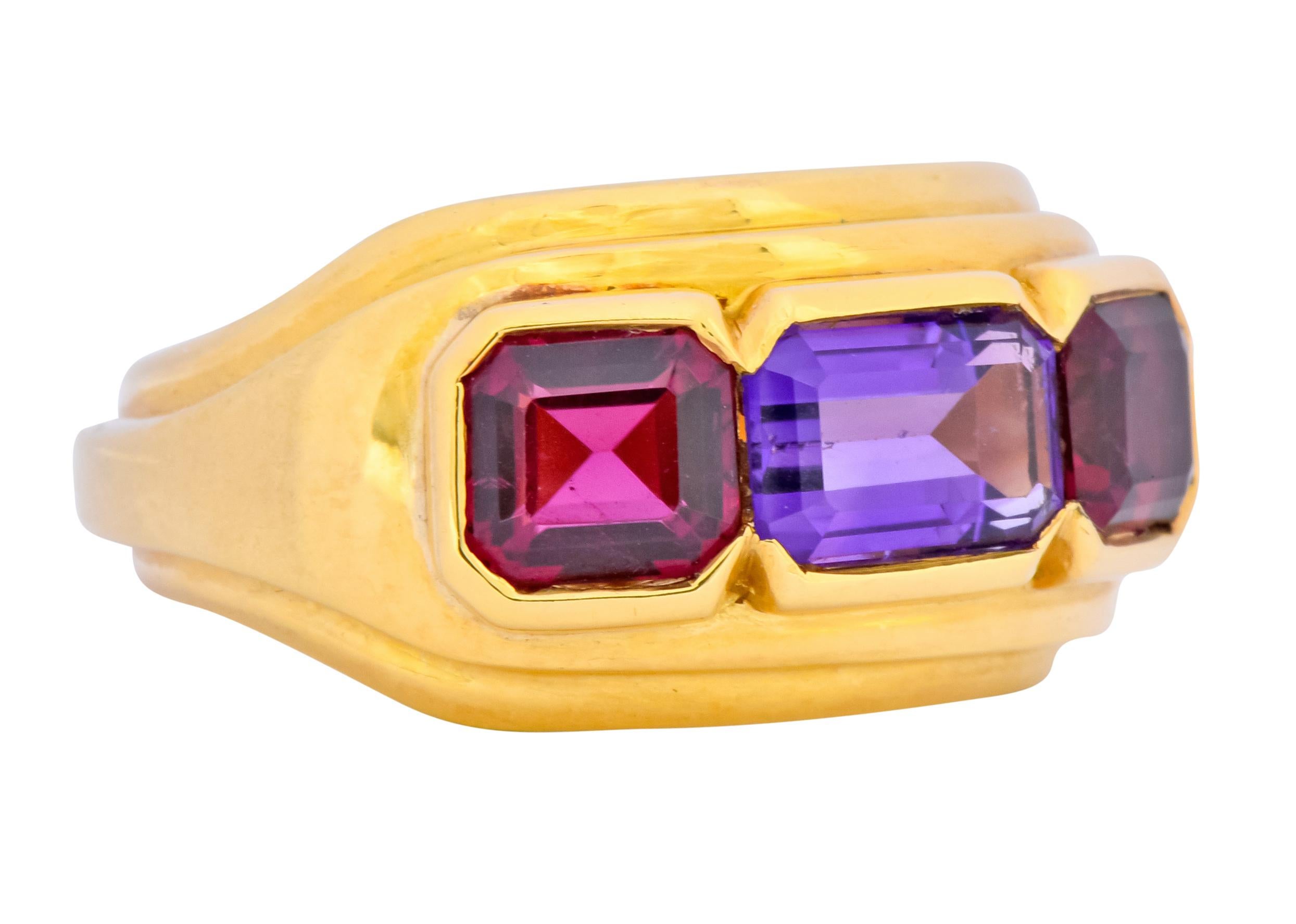 Band style ring centering a half bezel set rectangular step cut amethyst weighing approximately 0.82 carat, transparent and a rich royal purple

Flanked by two bezel set square step cut pink tourmalines measuring approximately 1.06 carat total,