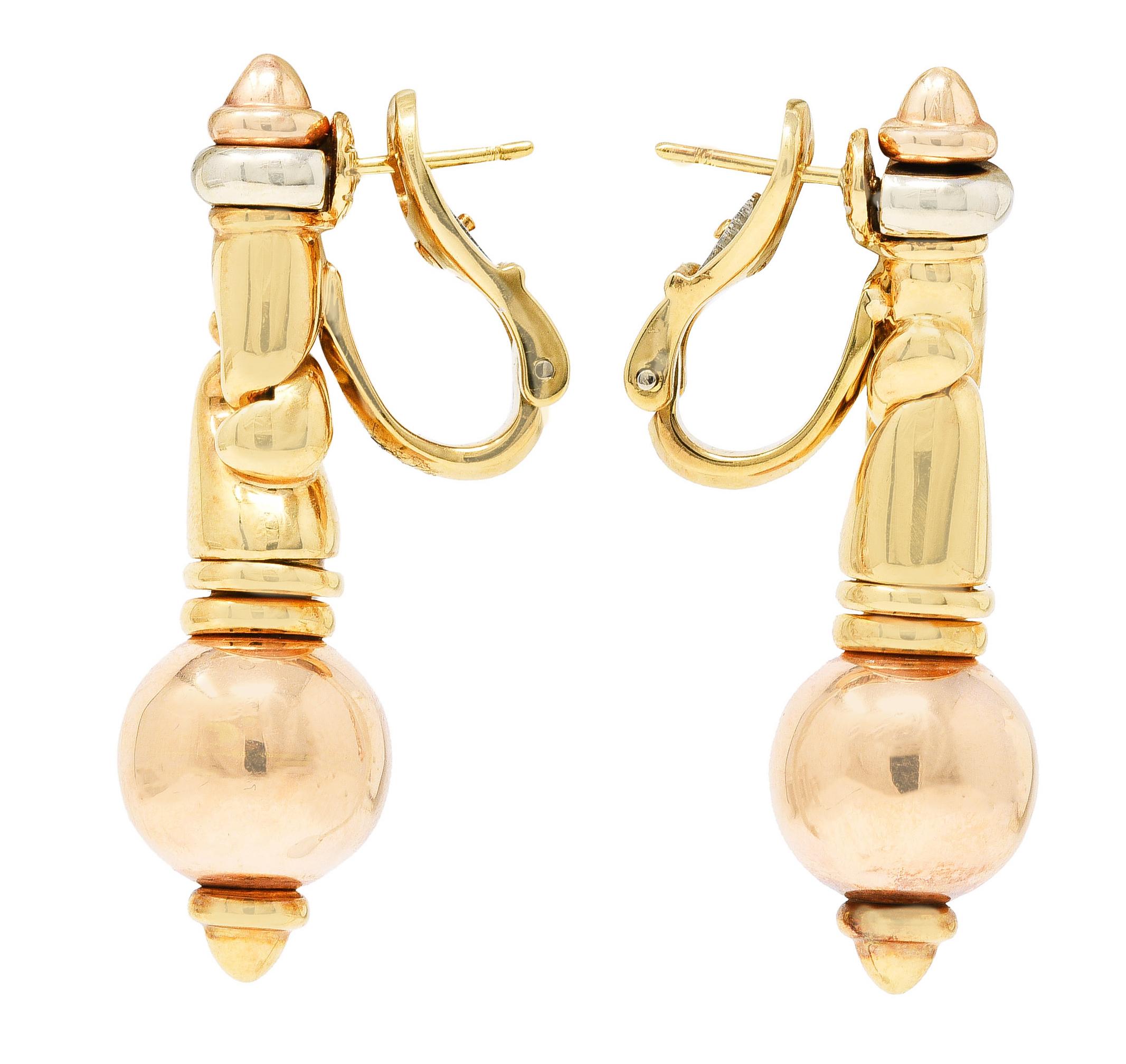 Earrings are comprised of yellow gold signature doppio cuore links. Suspending an 11.5 mm round rose gold bead. With rose and white gold segmented terminals. Completed by posts with hinged omega backs. Stamped 750 for 18 karat gold. Fully signed