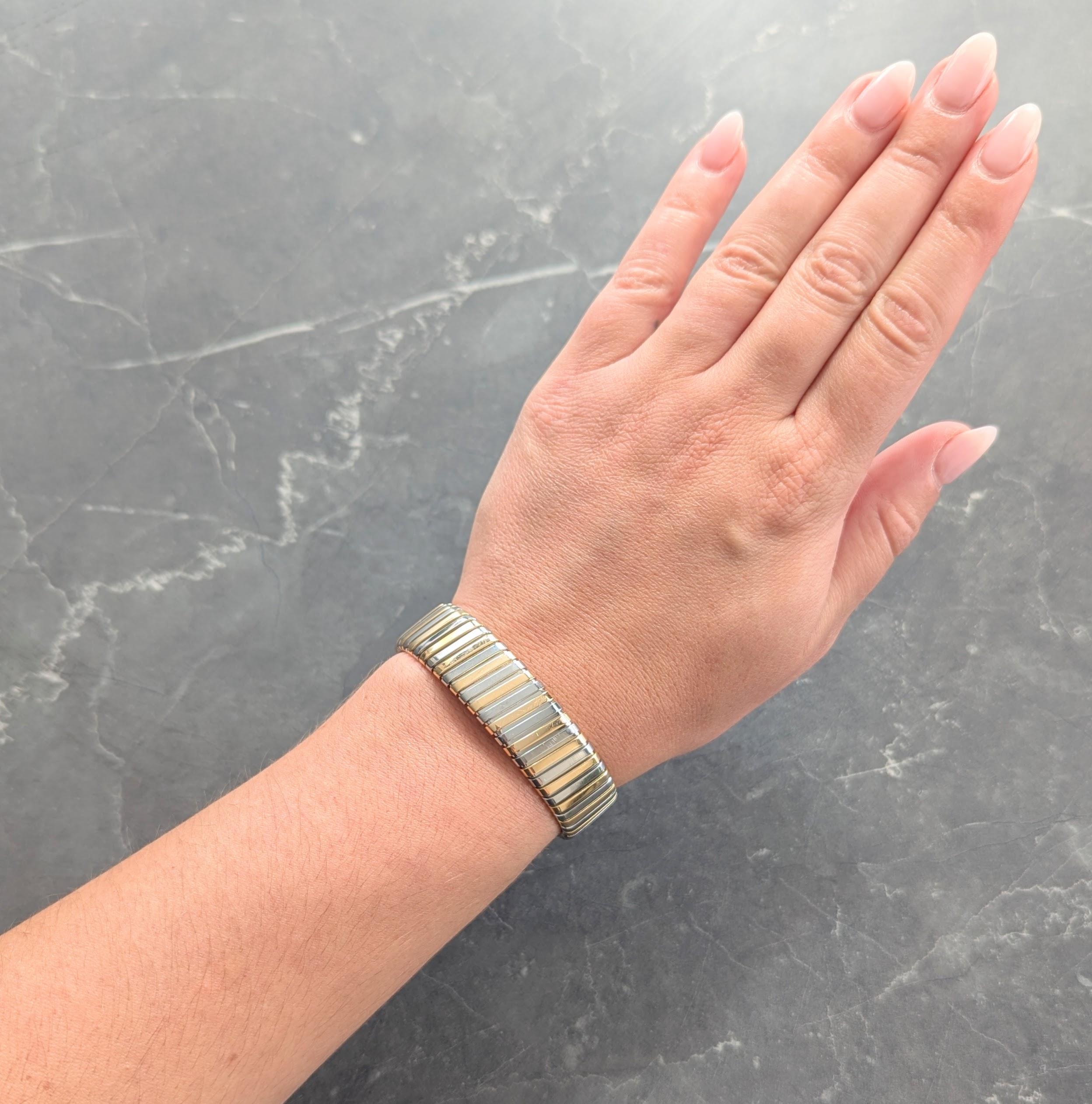 Progettato come bracciale tubogas con scanalature profonde
Composto da segmenti alternati di oro e acciaio
Con finitura lucida su tutta la superficie
Completato da terminali aperti a filo
Timbrato con i marchi di controllo italiani per l'oro a 18