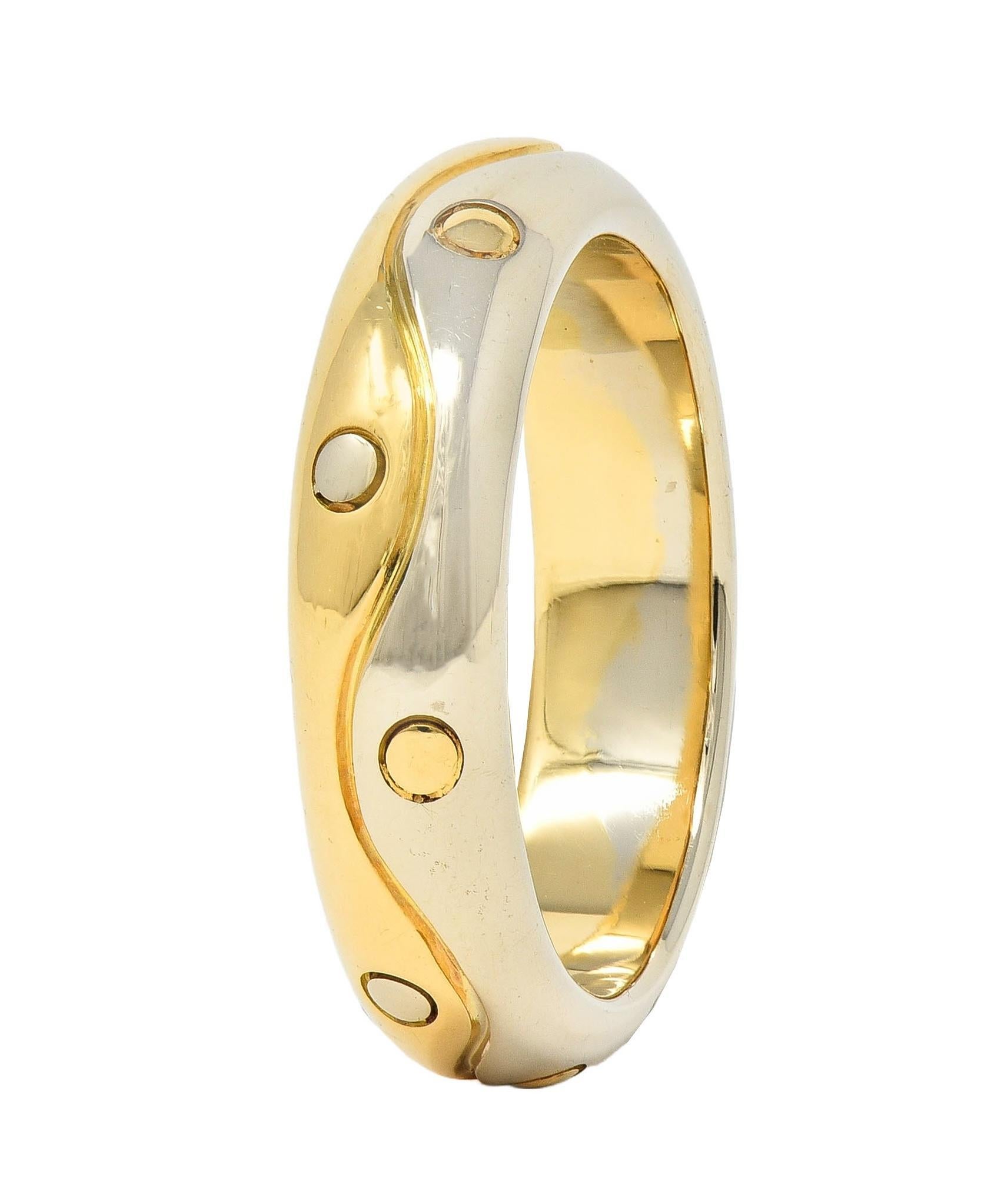 Band ring featured a grooved wave motif middle
Accentuated by yellow and white gold halves 
Accented by grooved dots of alternating gold 
Stamped 750 for 18 karat gold
Fully signed Bvlgari, Made in Italy
Circa: 1990s; from the Onda collection
Ring