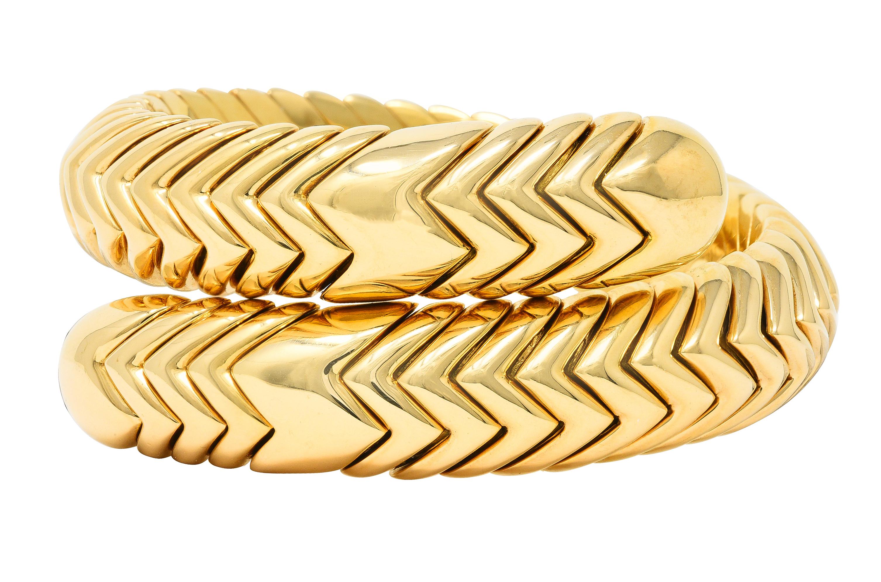 Bracelet is comprised of fitted chevron links - with considerable flex for wrapping. Featuring rounded bypass terminals. With high polish finish. Stamped 750 with Italian assay marks for 18 karat gold. Numbered and fully signed for Bvlgari. Circa: