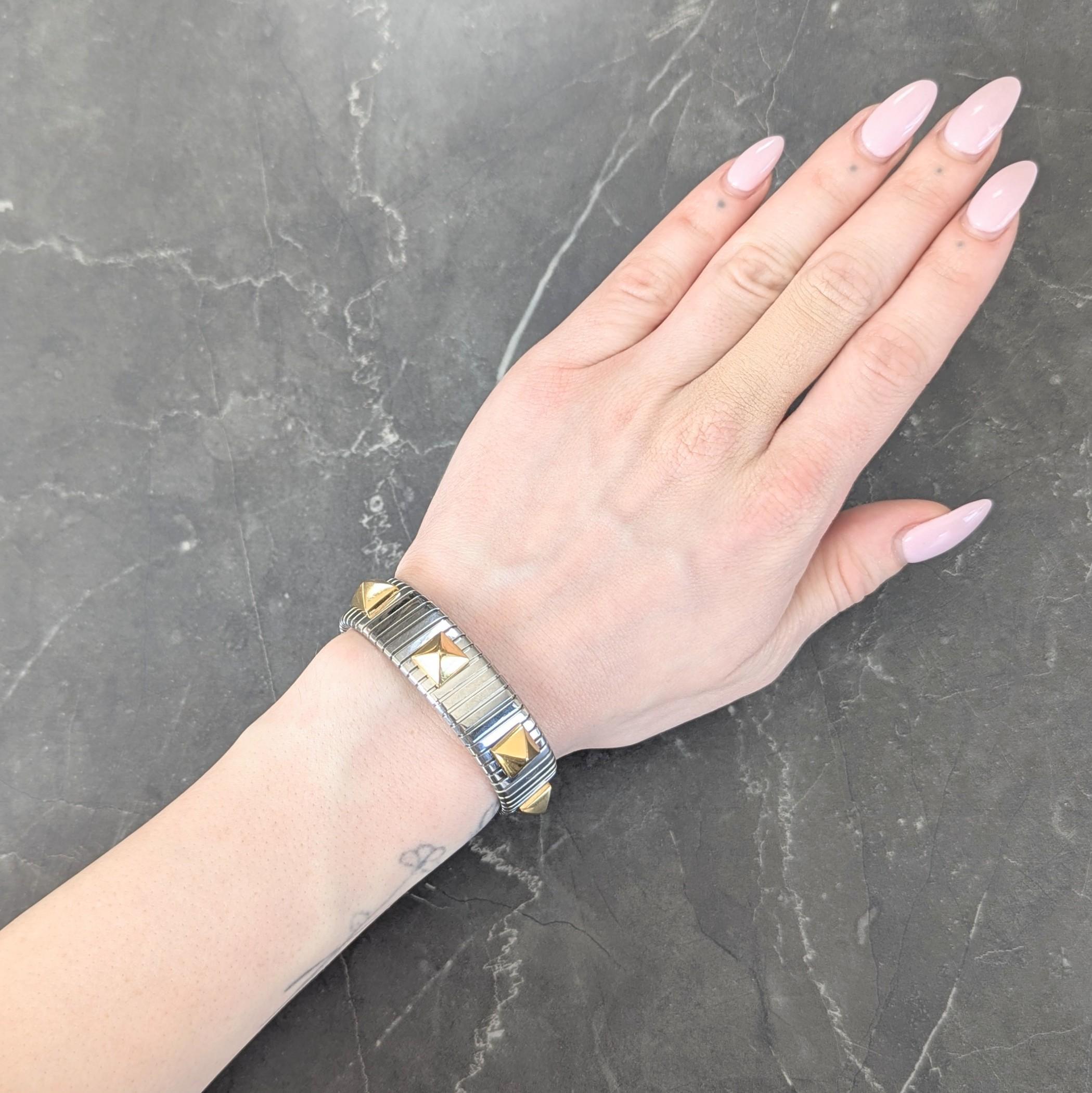 Comprised of deeply grooved stainless steel tubogas segments
Accented by yellow gold pyramid shaped studs
Completed by gold flush open terminals
Stamped with Italian assay marks for 18 karat gold
Tested as stainless steel
Numbered and fully signed