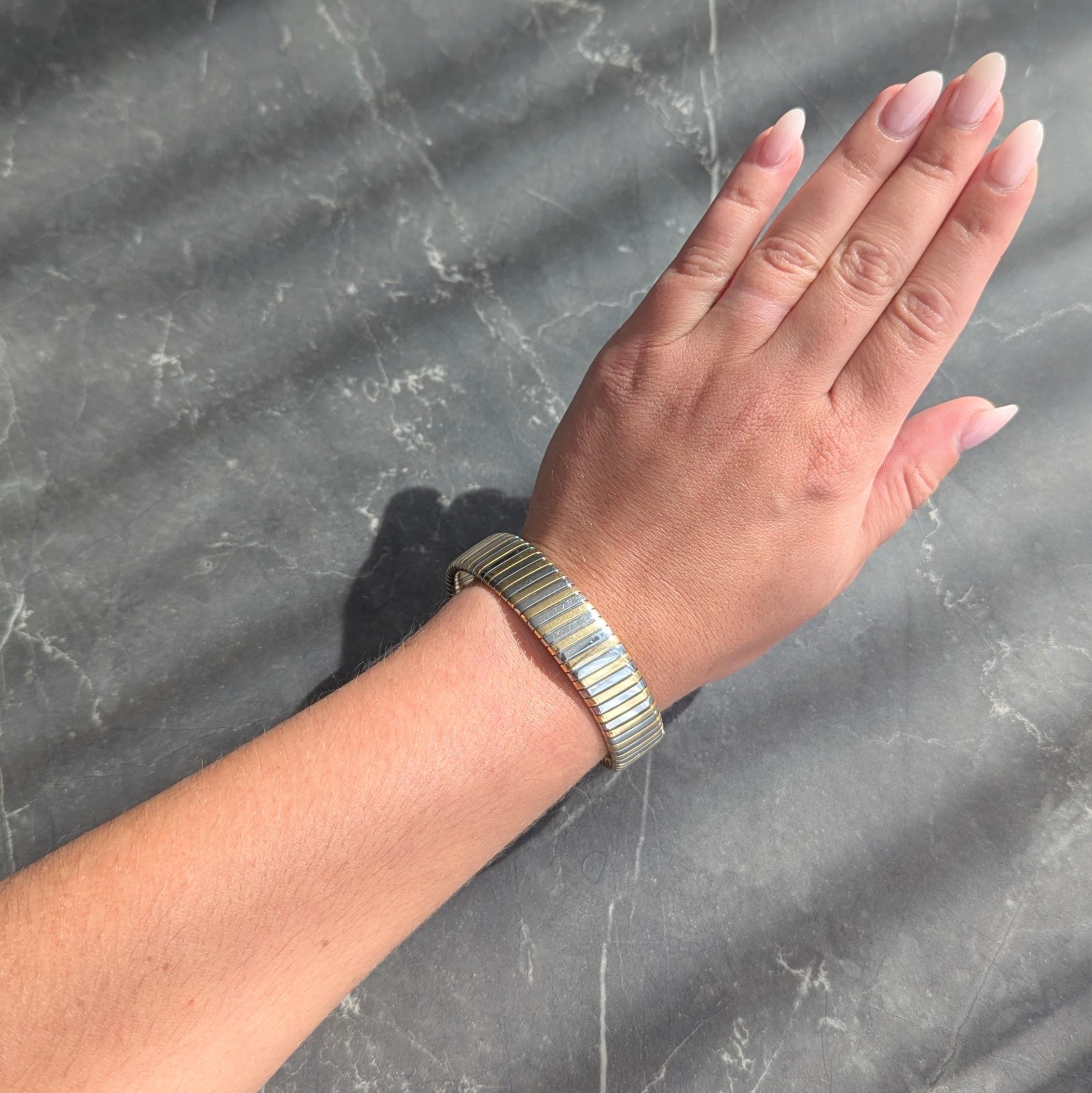 Progettato come bracciale tubogas con scanalature profonde
Composto da segmenti alternati di oro e acciaio
Con finitura lucida su tutta la superficie
Completato da terminali aperti a filo
Timbrato con i marchi di controllo italiani per l'oro a 18