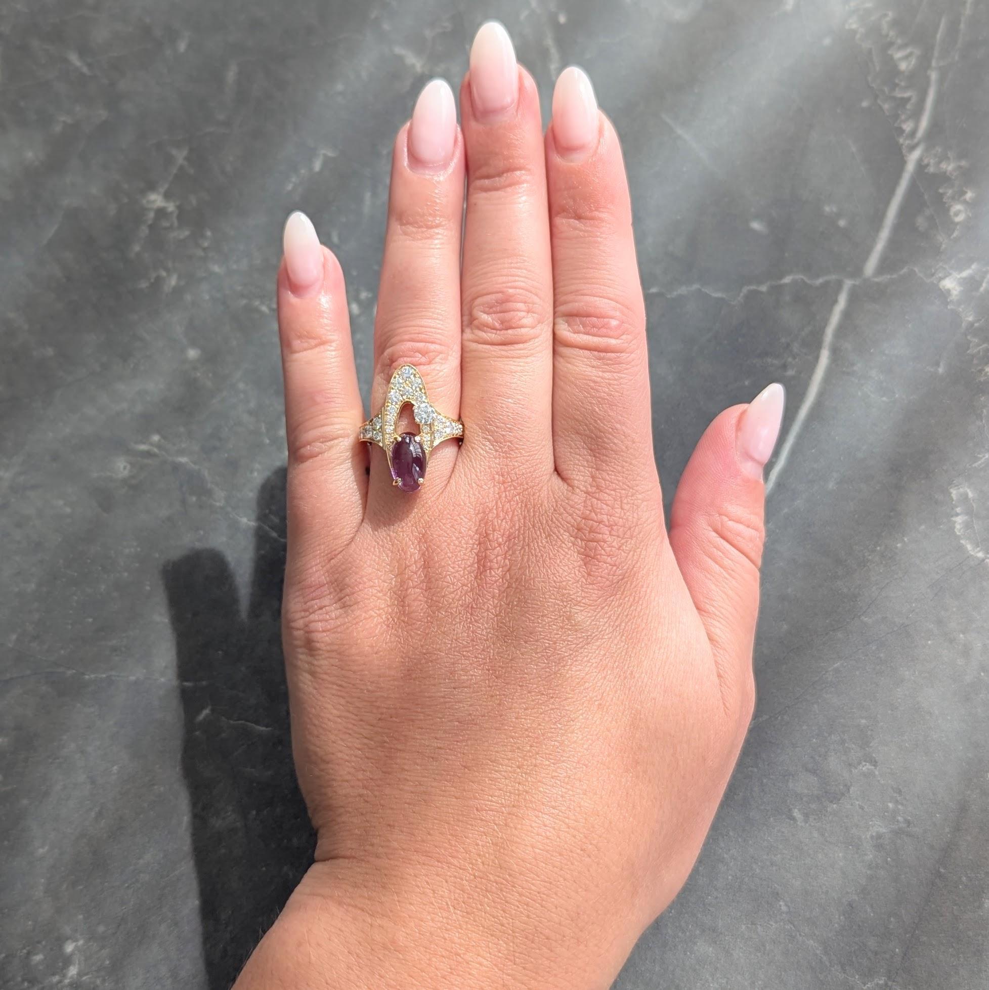 La bague est conçue comme une ellipse allongée en or jaune avec un centre ouvert.
Cabochon ovale d'améthyste pesant environ 2,10 carats. 
Transparent de couleur violet moyen et serti sur un côté de l'ellipse
Juxtaposé à un diamant rond de taille