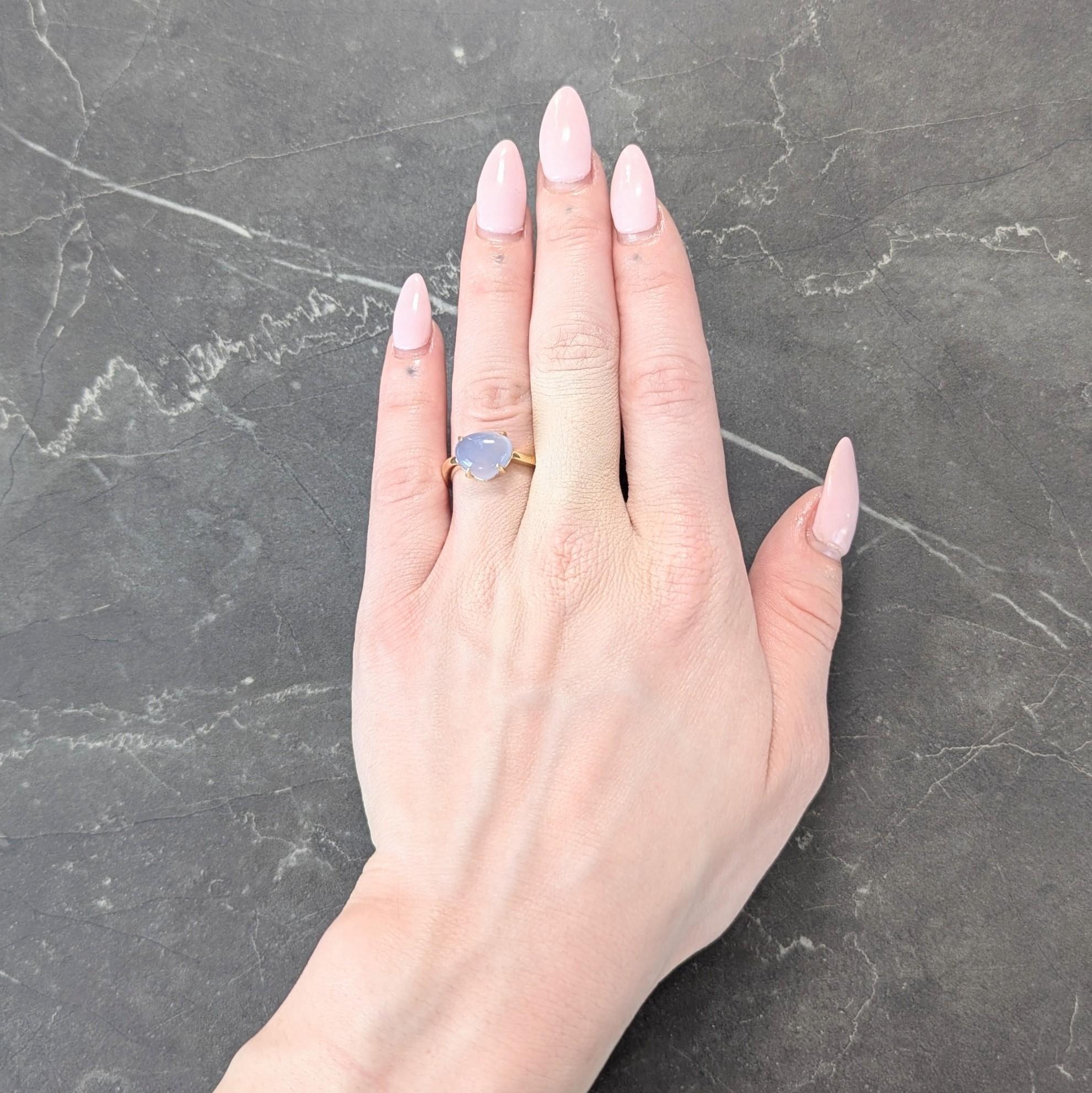 Centering a triangular shaped moonstone cabochon measuring 9.5 x 11.5 mm
Bluish gray in body color and displaying yellow adularescence
Set with talon prongs and flanked by swirling shoulders
With a high polish finish
Stamped with Italian assay marks