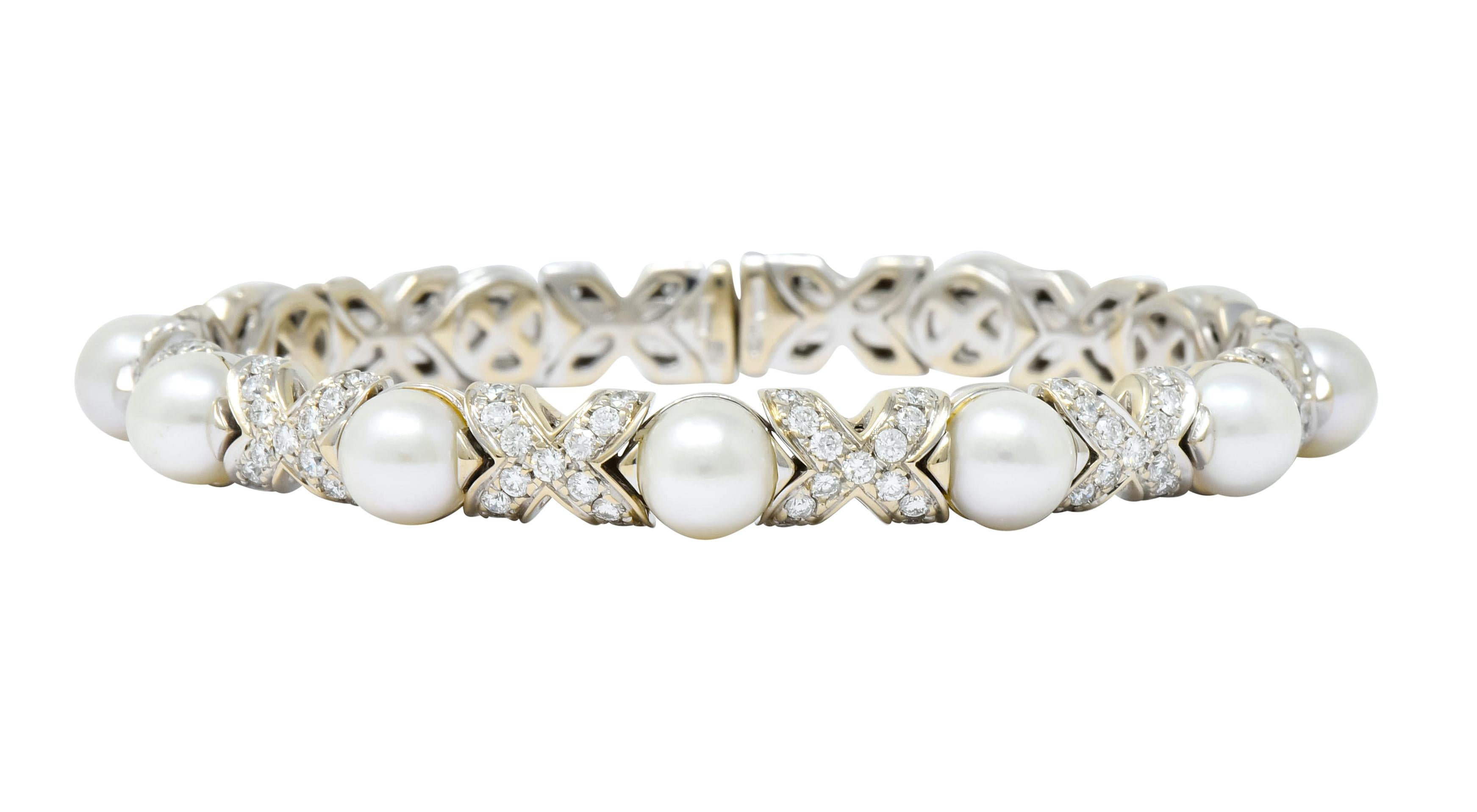 Flexible cuff style bracelet set fully around with round and cultured button pearls, very well-matched, white in body color with slight rosé overtones and good luster

Alternating with X motif, each bead set with round brilliant cut diamonds