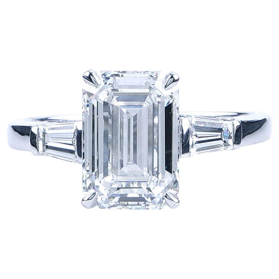 This magnificent Bulgari three stone diamond engagement ring is made of platinum and weighs 2.4 DWT (approx. 3.73 grams). Taking center stage is a GIA certified emerald cut diamond grading F in color, VS1 in clarity, and weighing 2.70 carats. It is