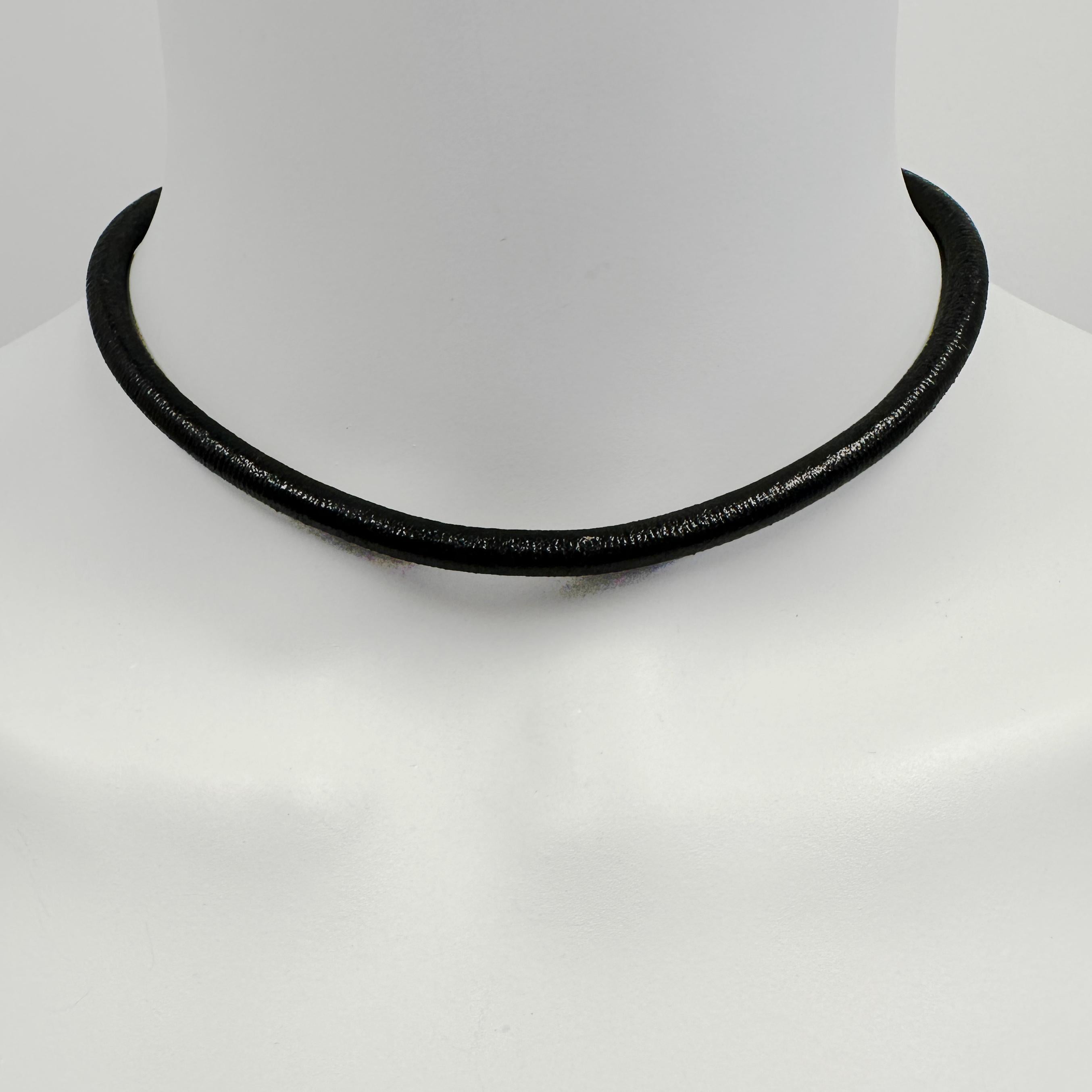 A soft, slightly glossy length of black leather makes for a bold choker that can be worn a number of different ways.  The big lobster clasp, in rich 18 karat yellow gold, can be worn back or front, and you can hang pendants either directly on the