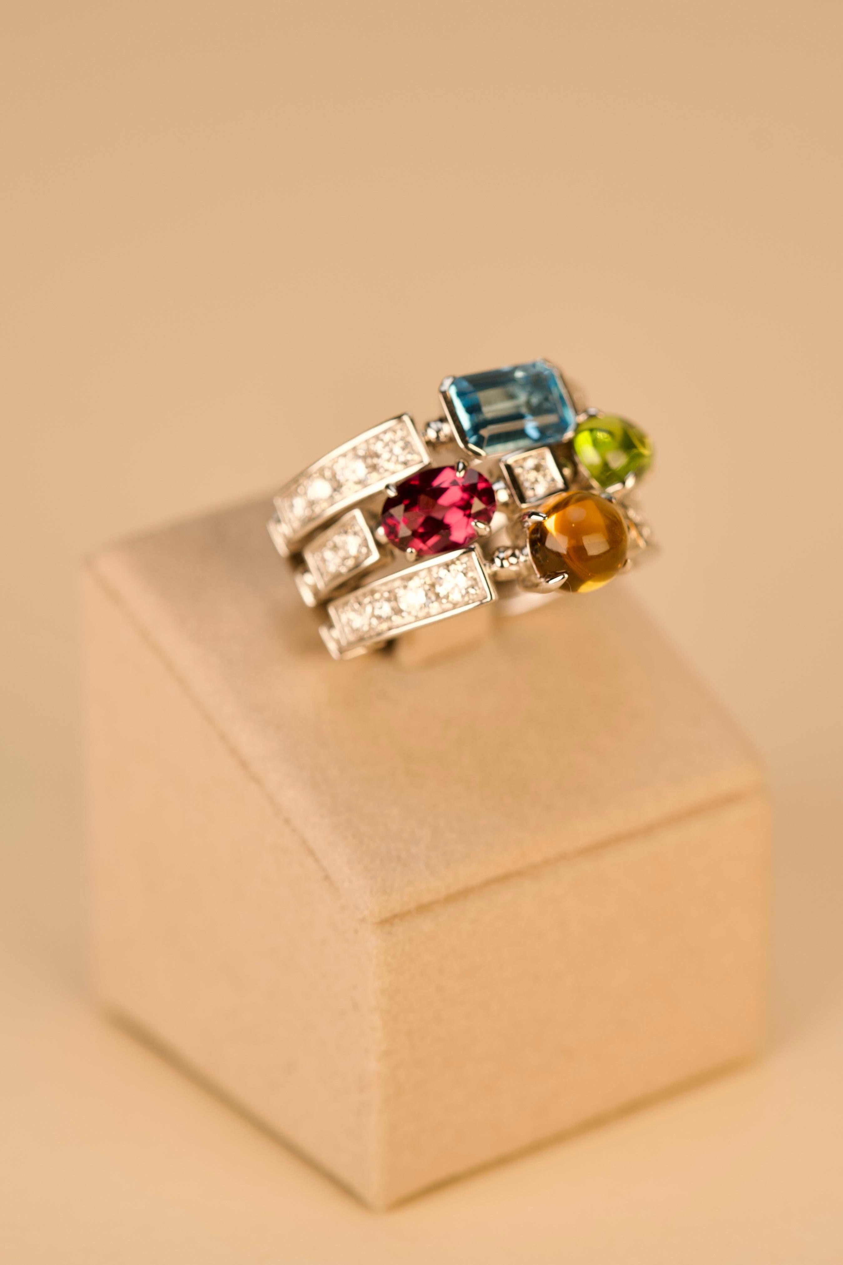 Réalisée en or blanc 18 carats, cette bague cocktail en or Bulgari Allegra Citrine Tourmaline Topaze Améthyste Diamant capture l'esprit joyeux qui définit la collection Allegra. Le bracelet audacieux et sculptural est orné de trois rangées