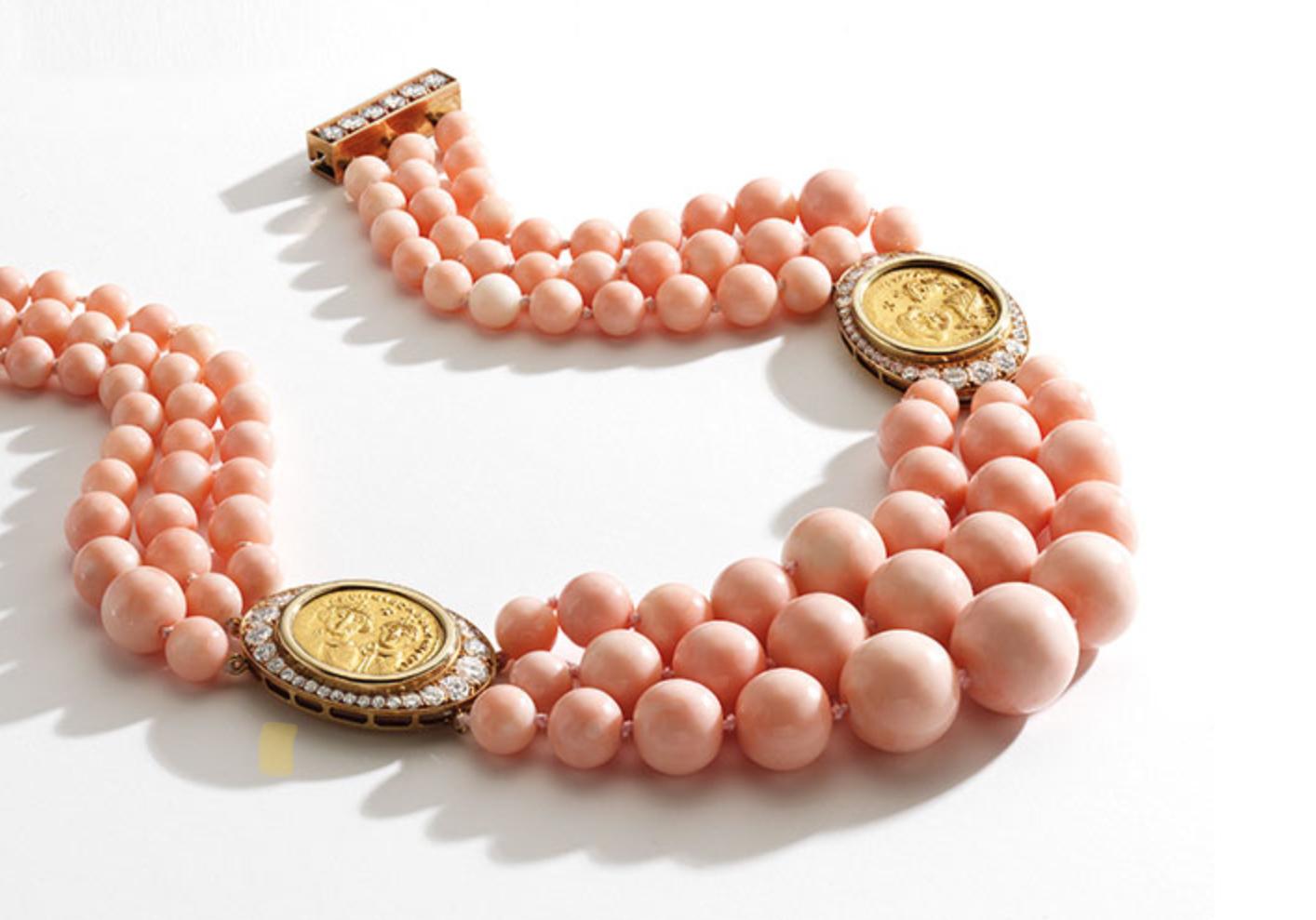 An unusual triple-strand necklace of graduated design, composed of coral beads measuring approximately 16.0 to 6.8 mm, gathered at the sides with two gold coins, the reverse to the mountings of each inscribed, ‘Heraclius & Heraclius Constantinus