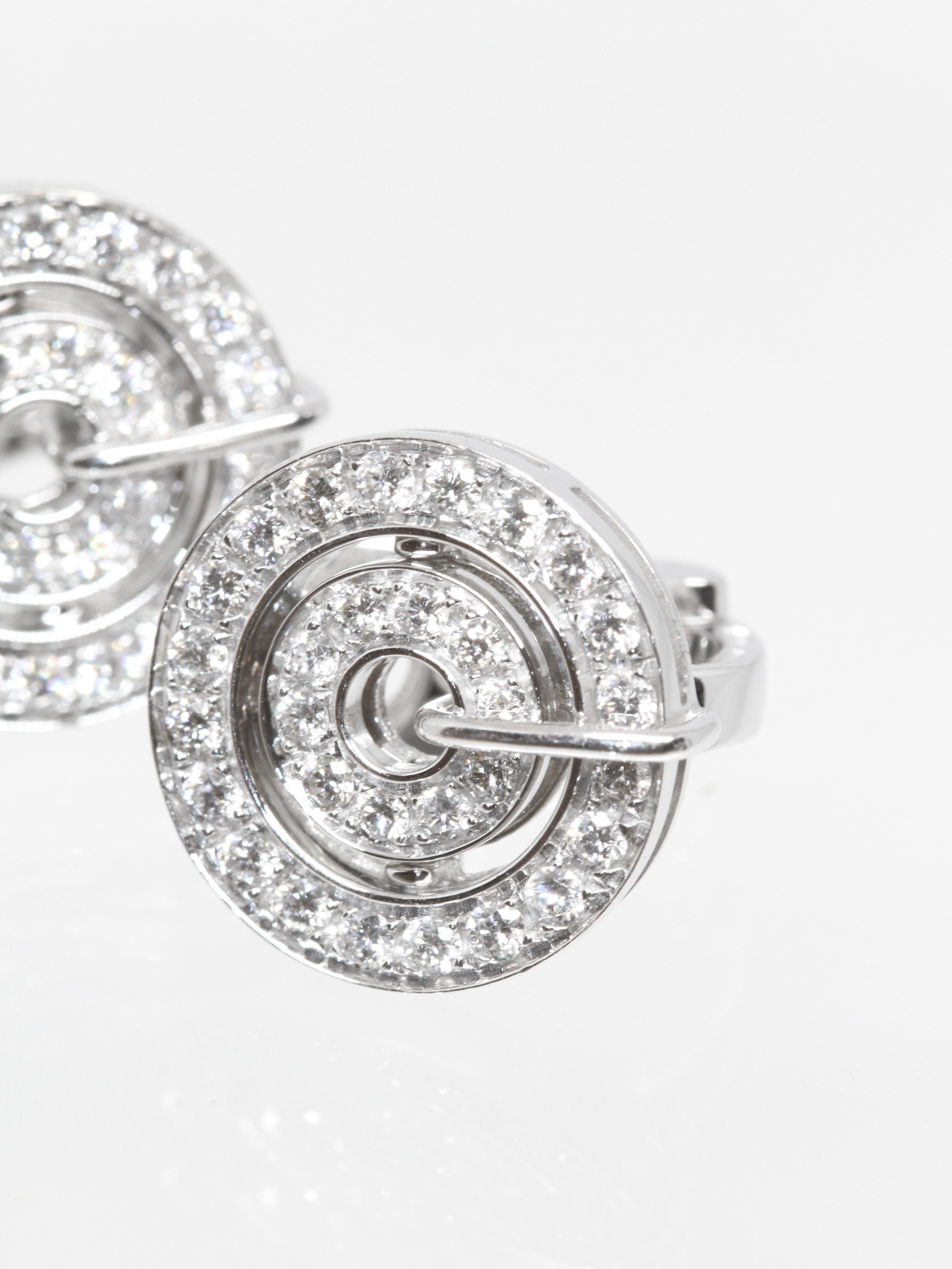 A beautiful pair of 18k white gold diamond earrings from the Astrale collection from the house of Bvlgari. 
The round earrings are each set with an inner circle with 10 diamonds and the outer with 20 diamonds. 
They have post and hinged clip