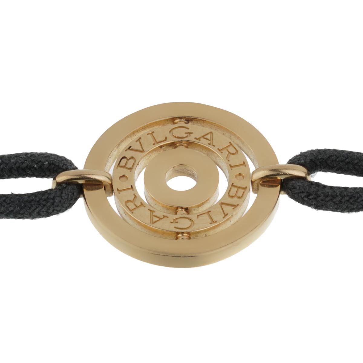 A vintage Bulgari Astrale Cerci bracelet showcasing the iconic Bulgari Bulgari motif on a black cotton string. The bracelet measures 6