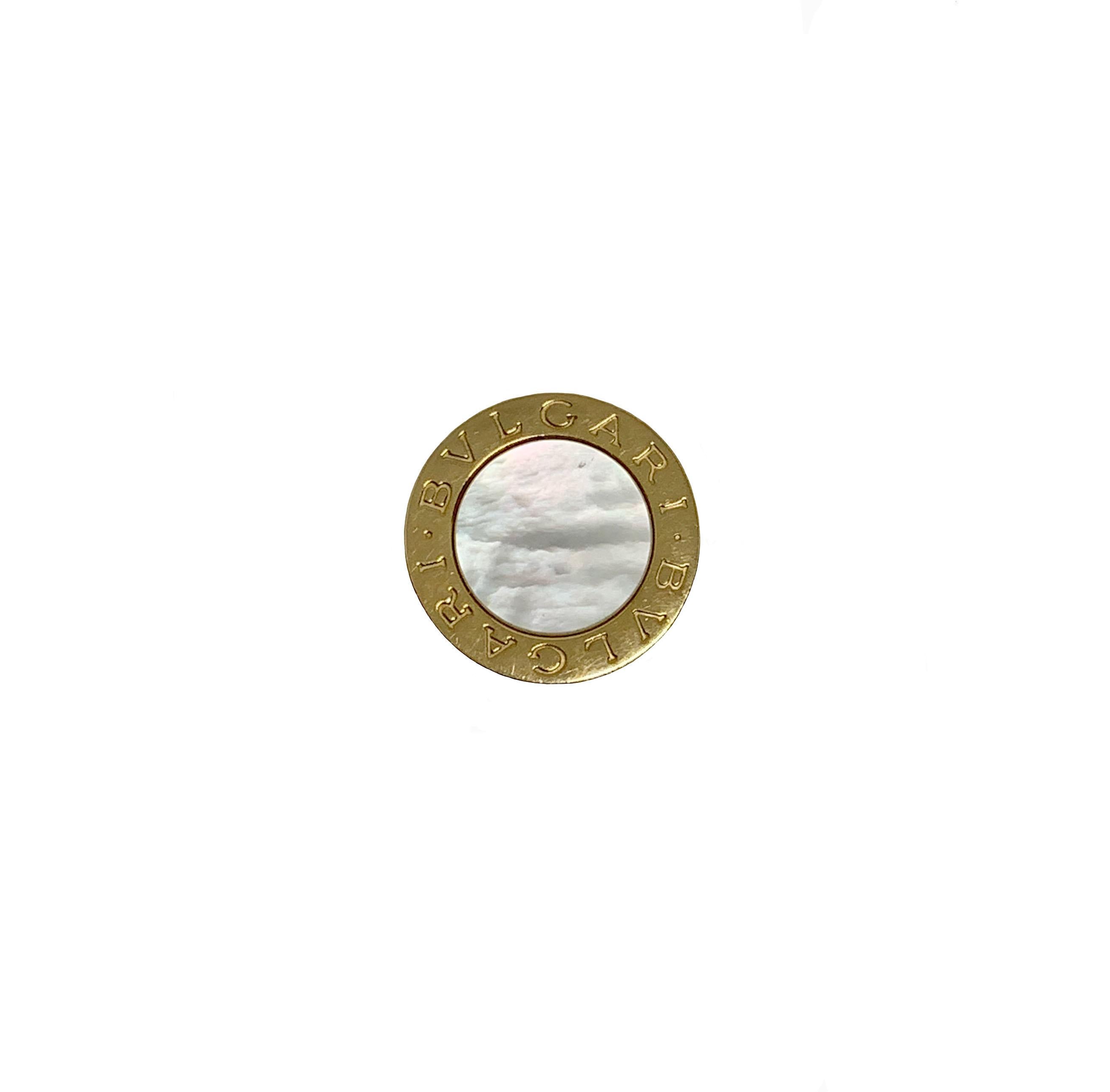 Part of the Bulgari Bulgari collection, this pre-owned 18K Yellow Gold Split Shank ring  is composed of one beautiful disk in white mother of pearl, enhanced with an engraved border 