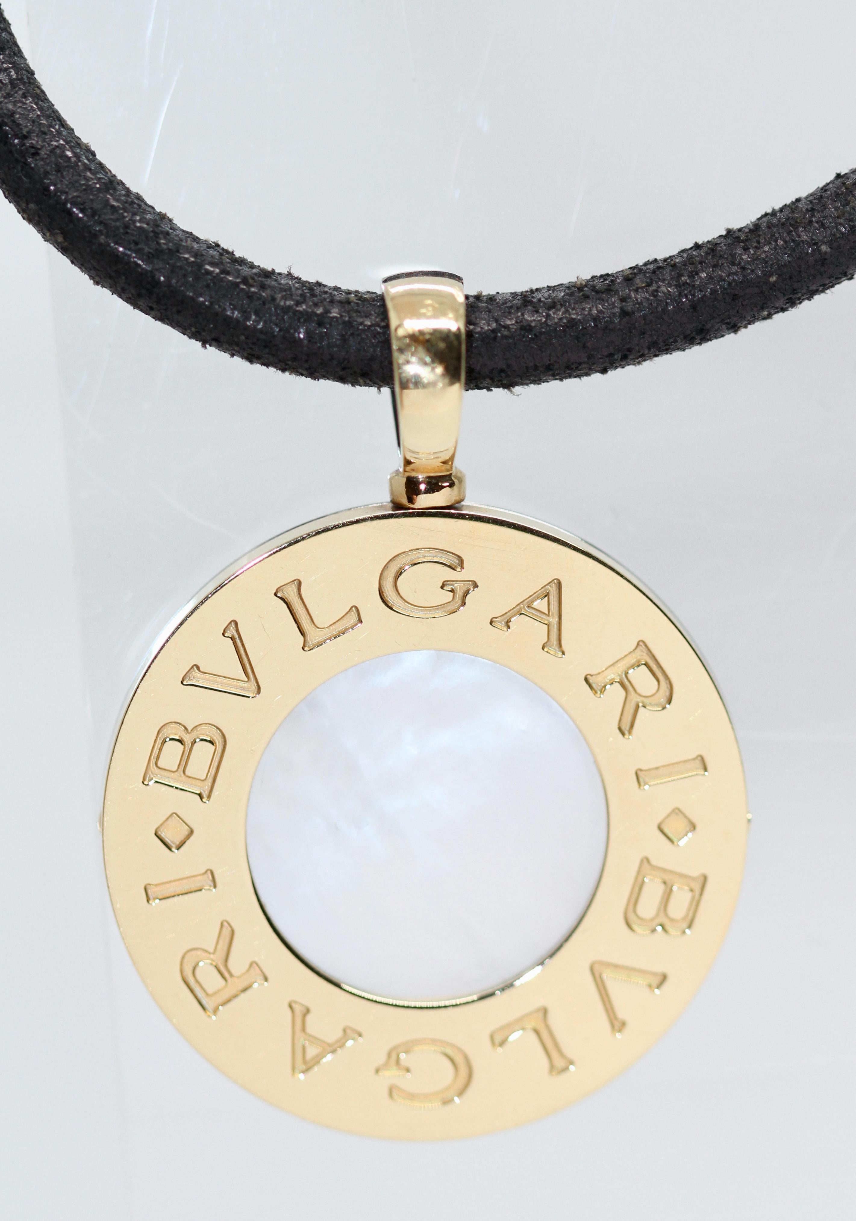 Dieses ikonische Stück aus dem Hause Bvlgari ist ein zeitloser, aus zweiter Hand gefertigter Münzanhänger. Eine Seite der Münze ist aus 18-karätigem Gelbgold mit einem Perlmuttkern gefertigt, die Rückseite besteht aus Stahl mit einem schwarzen
