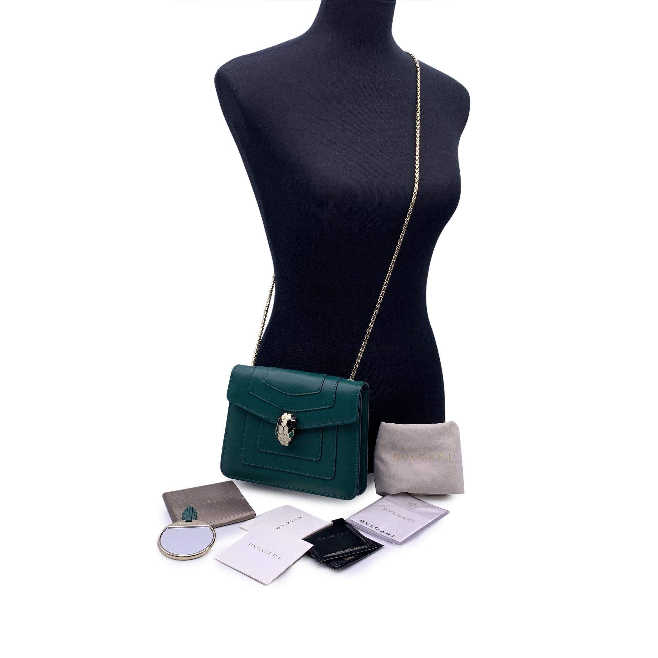 Elegant Bulgari 'Serpenti Forever' Shoulder bag. Crafted in green leather , it features a beautiful Serpenti snake's head clasp on the front in gold metal, white and black enamel with green malachite eyes. Gold metal shoulder strap. Purple grosgrain