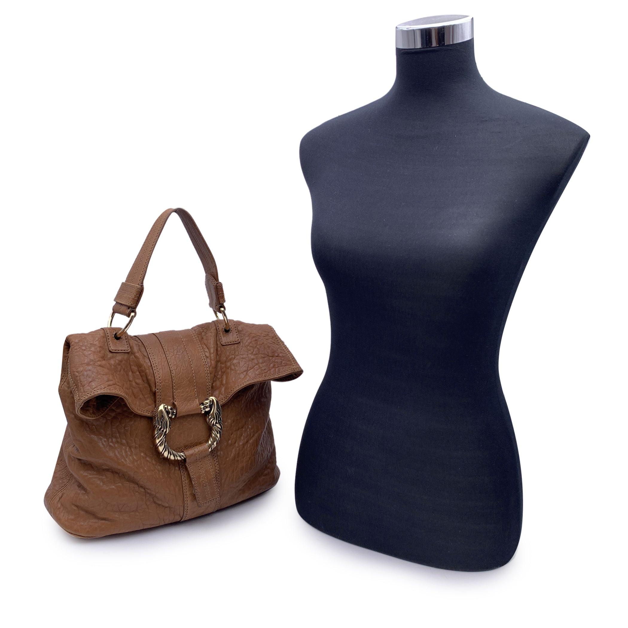 Bvlgari Bulgari 'Leoni' bag, crafted in light brown leather. Gold metal Leoni ring on the front. Foldable design with clap closure on the front. Fabric lining. 1 side zip pocket and 2 side open pockets inside. Rear pocket with magnetic button