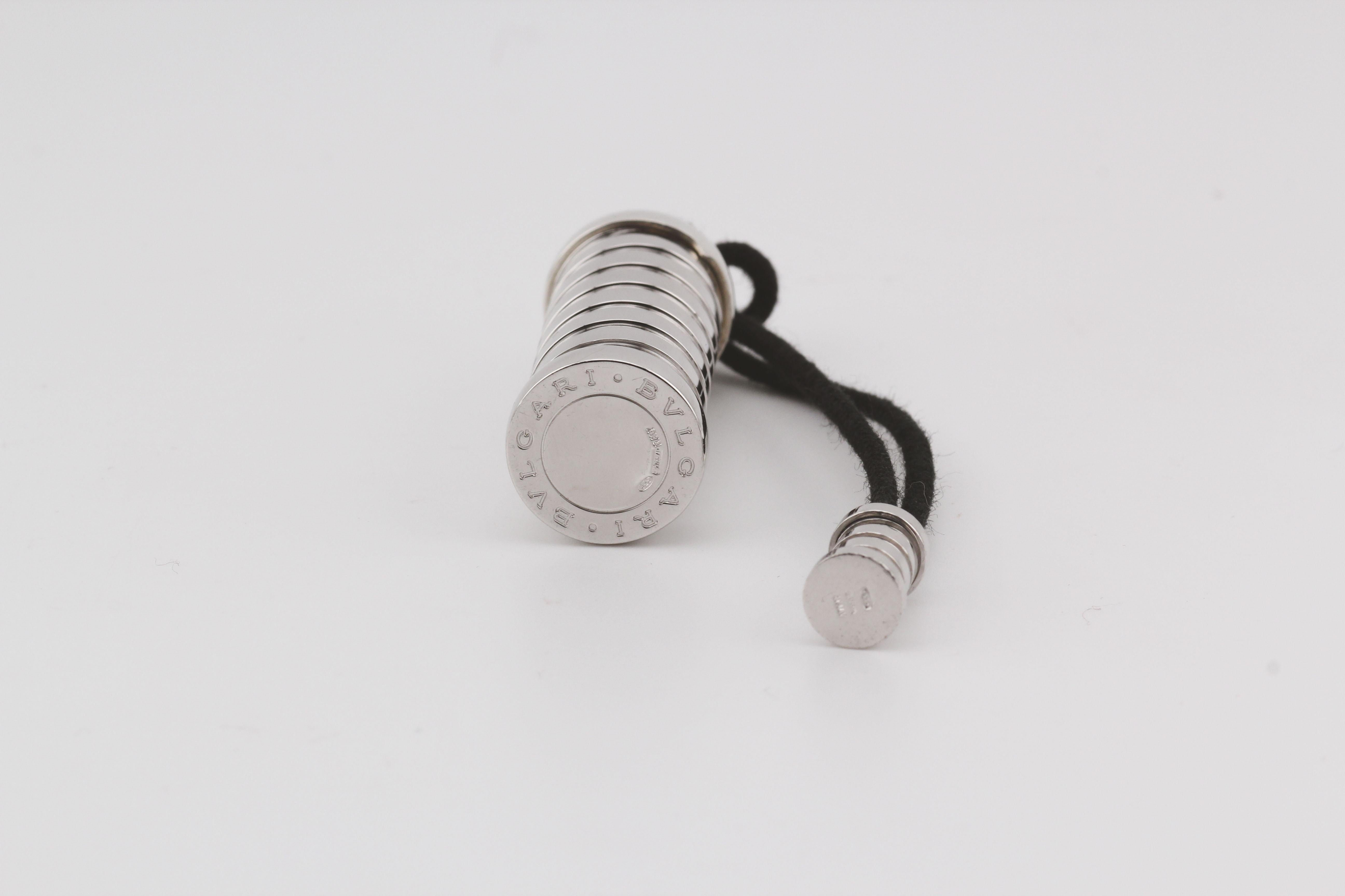 The Bulgari B. Zero 925 Sterling Silver Pill Box Case with Leather Cord is a luxurious, modern accessory that reflects Bulgari’s signature bold and sophisticated style. Crafted from high-quality 925 sterling silver, this pill box takes inspiration