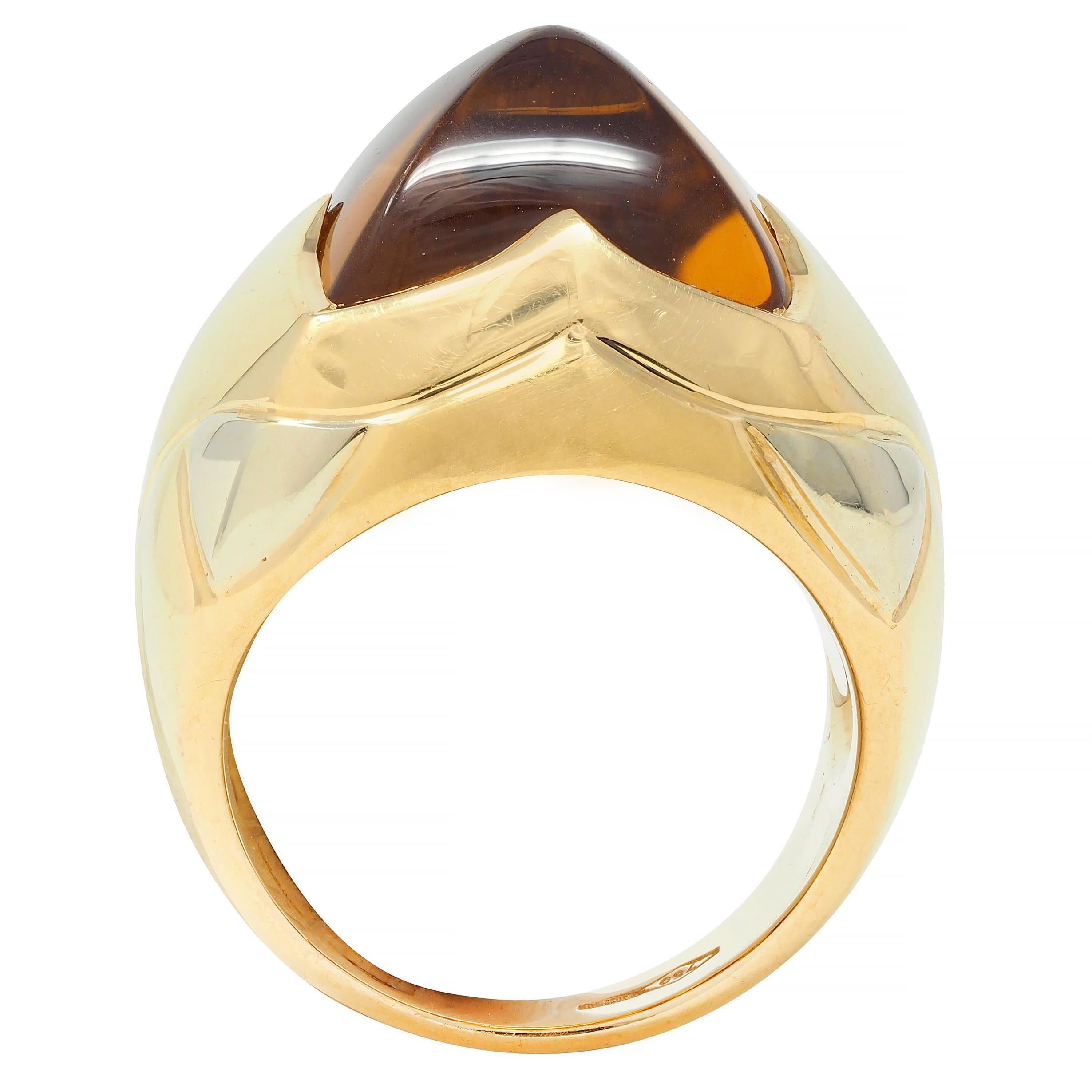 Designed as a domed pyramid form comprised of segmented two-tone gold
Centering a pyramid-shaped citrine cabochon 
Transparent medium brownish yellow
Accented by white gold petal motifs
Completed by a yellow gold shank
Stamped with Italian assay