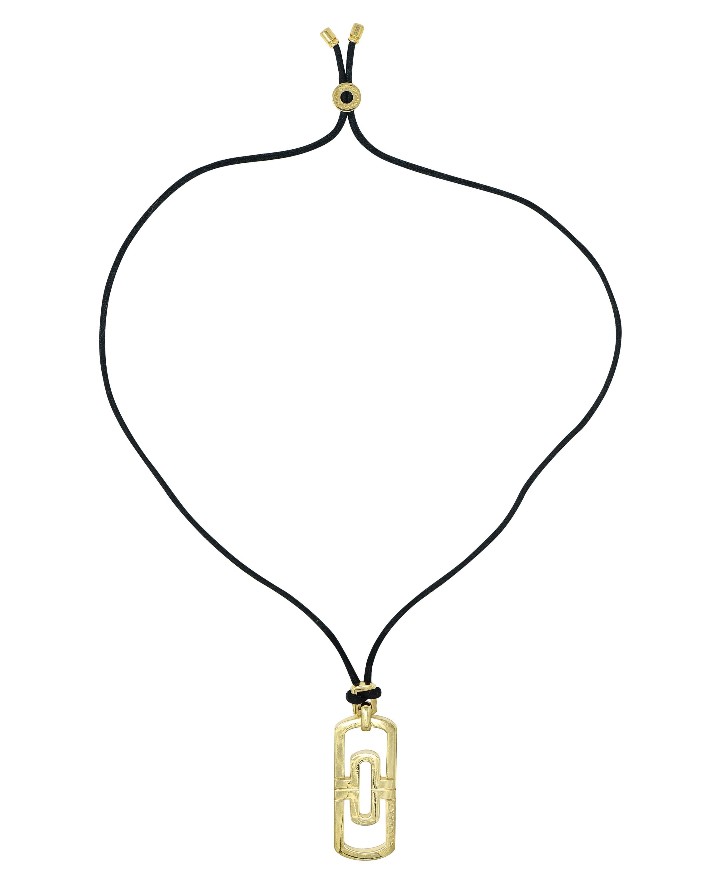 Designed as a black cord suspending an elongated cushion-shaped pendant via rectangular bale 
Displaying a pierced geometric 