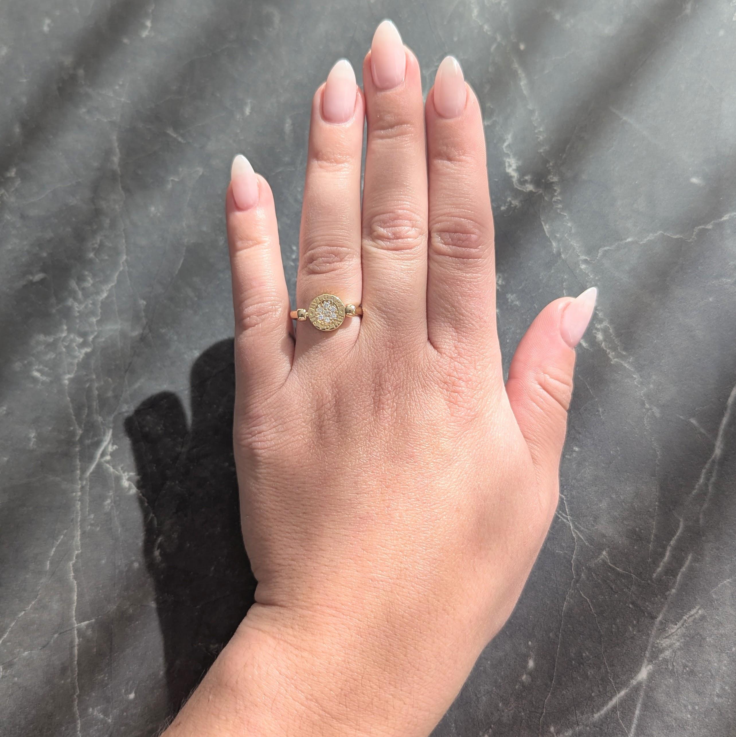 Der Siegelring zentriert eine kreisförmige Scheibe von 11,0 mm Durchmesser, die sich auf einer Achse dreht.
Eine Seite ist mit einer Reihe runder Diamanten im Brillantschliff besetzt
Mit einem Gesamtgewicht von etwa 0.20 Karat - augenrein und