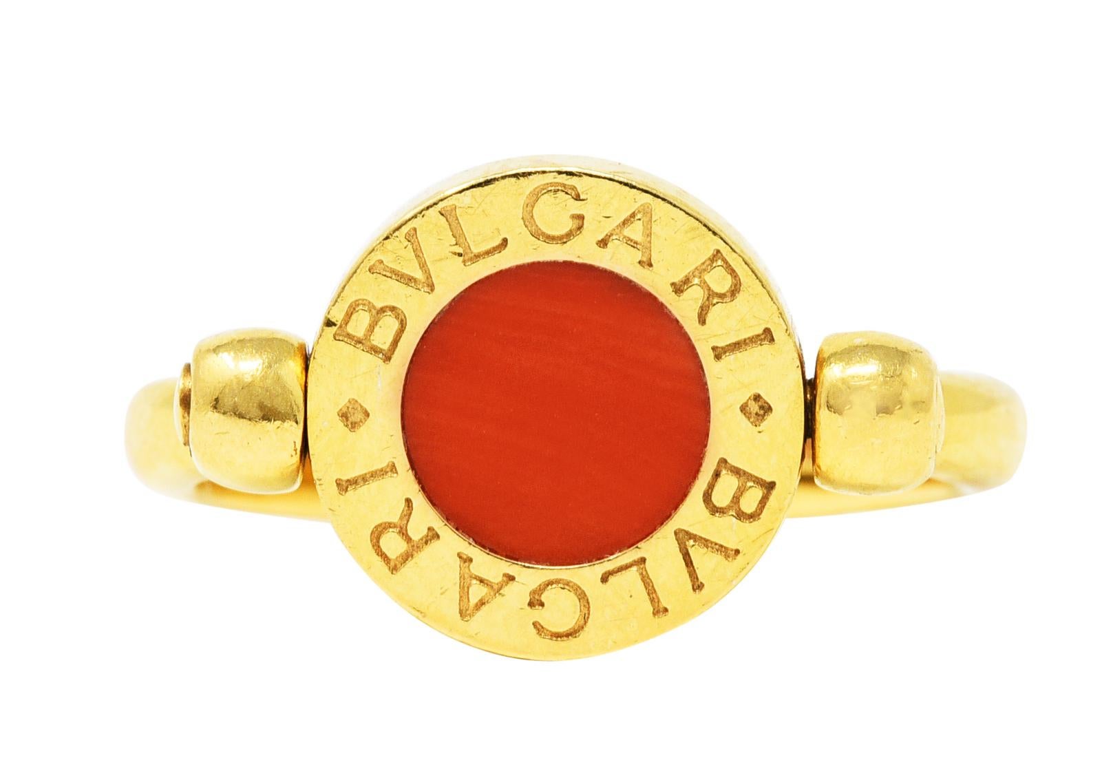 Band ring centers an 11.0 mm circular center that flips on an axis

One side features an inlaid circular tablet of coral - opaque with pastel reddish orange color

Opposite side features an inlaid circular tablet of onyx - opaque black with