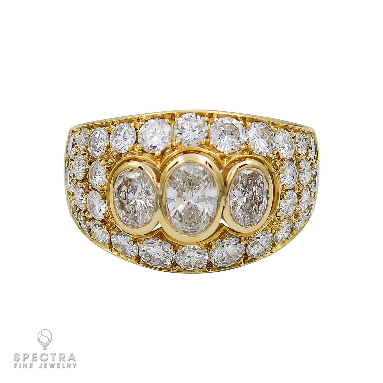 A beautiful cocktail ring made by Bulgari in Italy.
The ring is featuring three oval diamonds in the center accented by round diamonds. 
Total diamond weight is 4 carats. Diamonds are estimated as E-F-G color, VS clarity.
Metal 18k yellow gold,