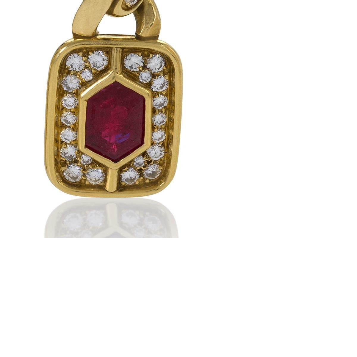A pair of Italian late-20th century 18 karat gold earrings with rubies and diamonds by Bulgari. Both the elegantly petite tops and the substantial drops of these earrings feature a hexagonal ruby of exceptional color framed by two plaques of
